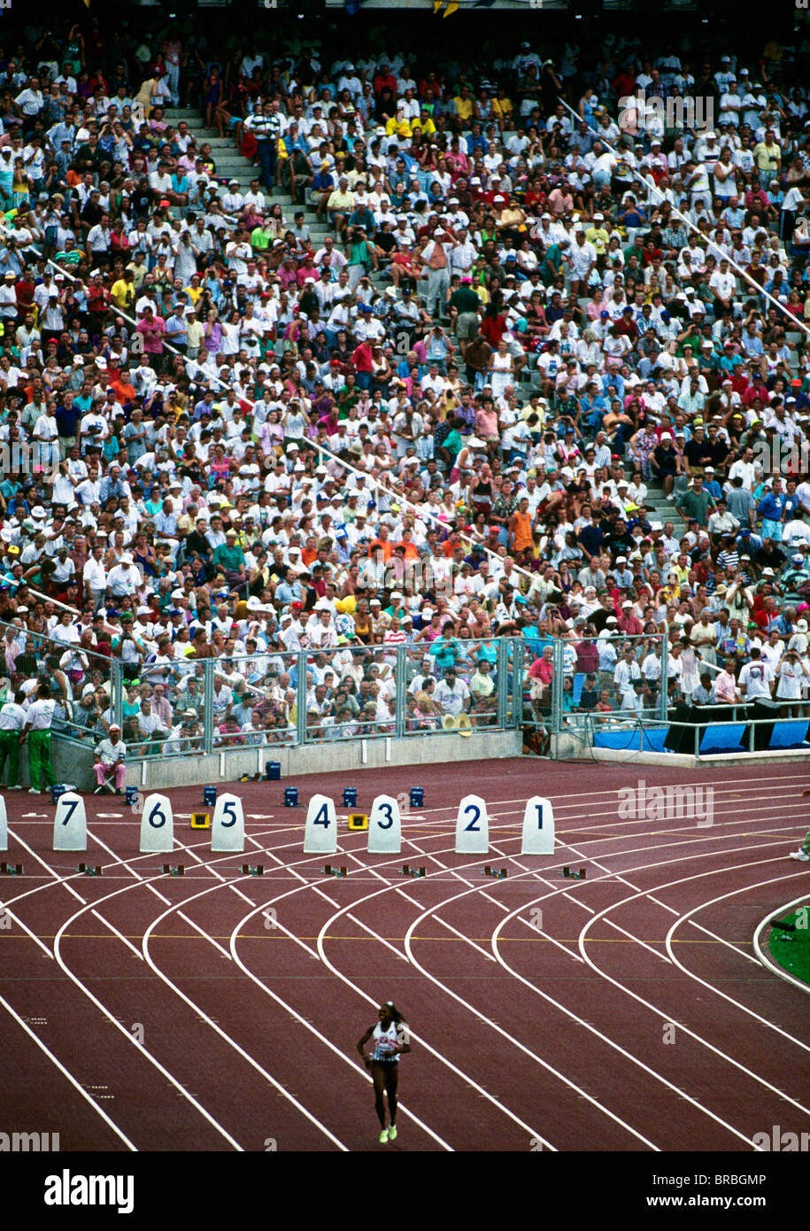 Spectators at a large track meet look along the 100 meters track lanes