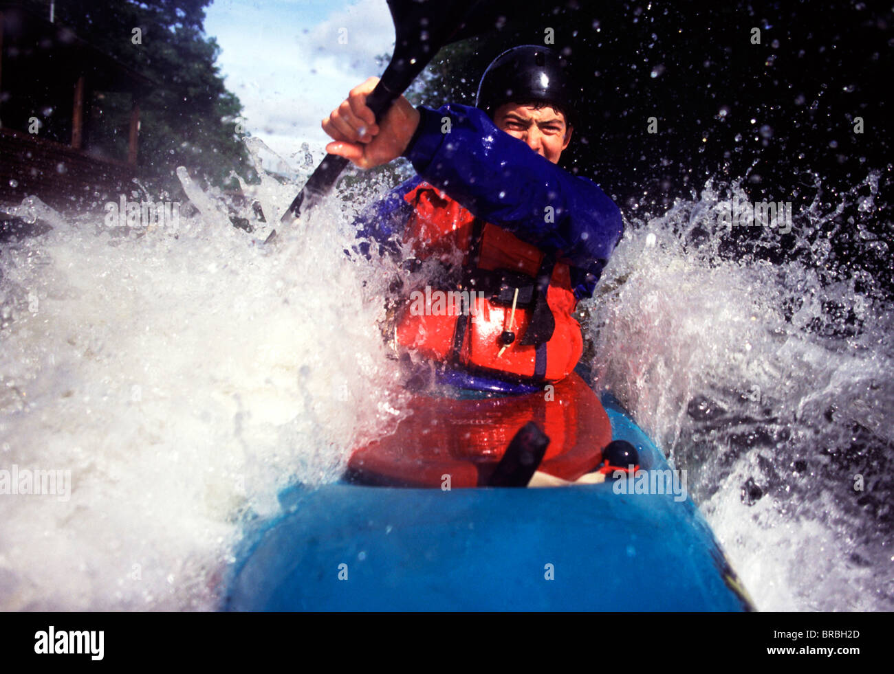Young man navigating his kayak through rough water Stock Photo - Alamy