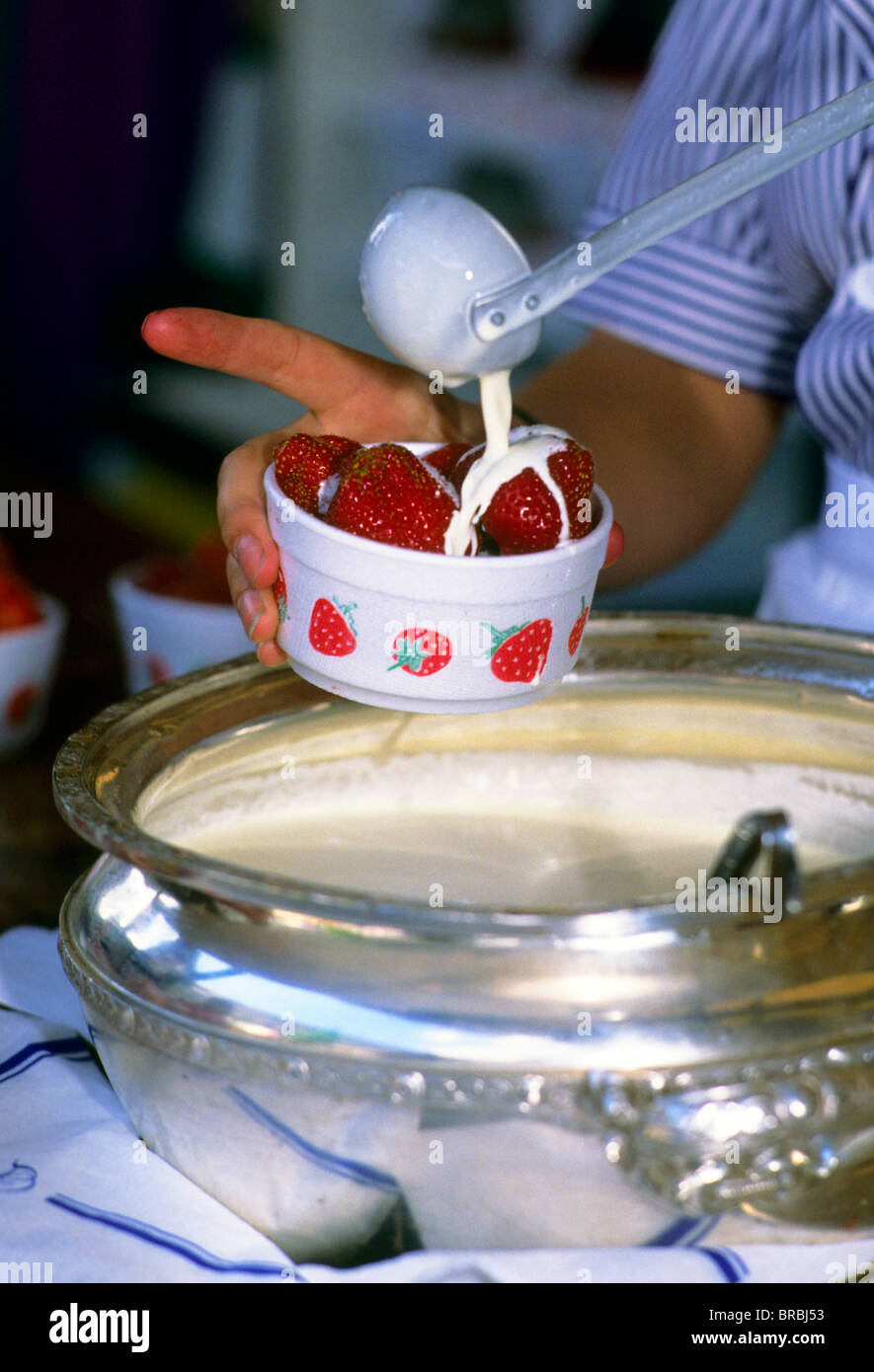 Server pouring cream over strawberries at a tennis match Stock Photo