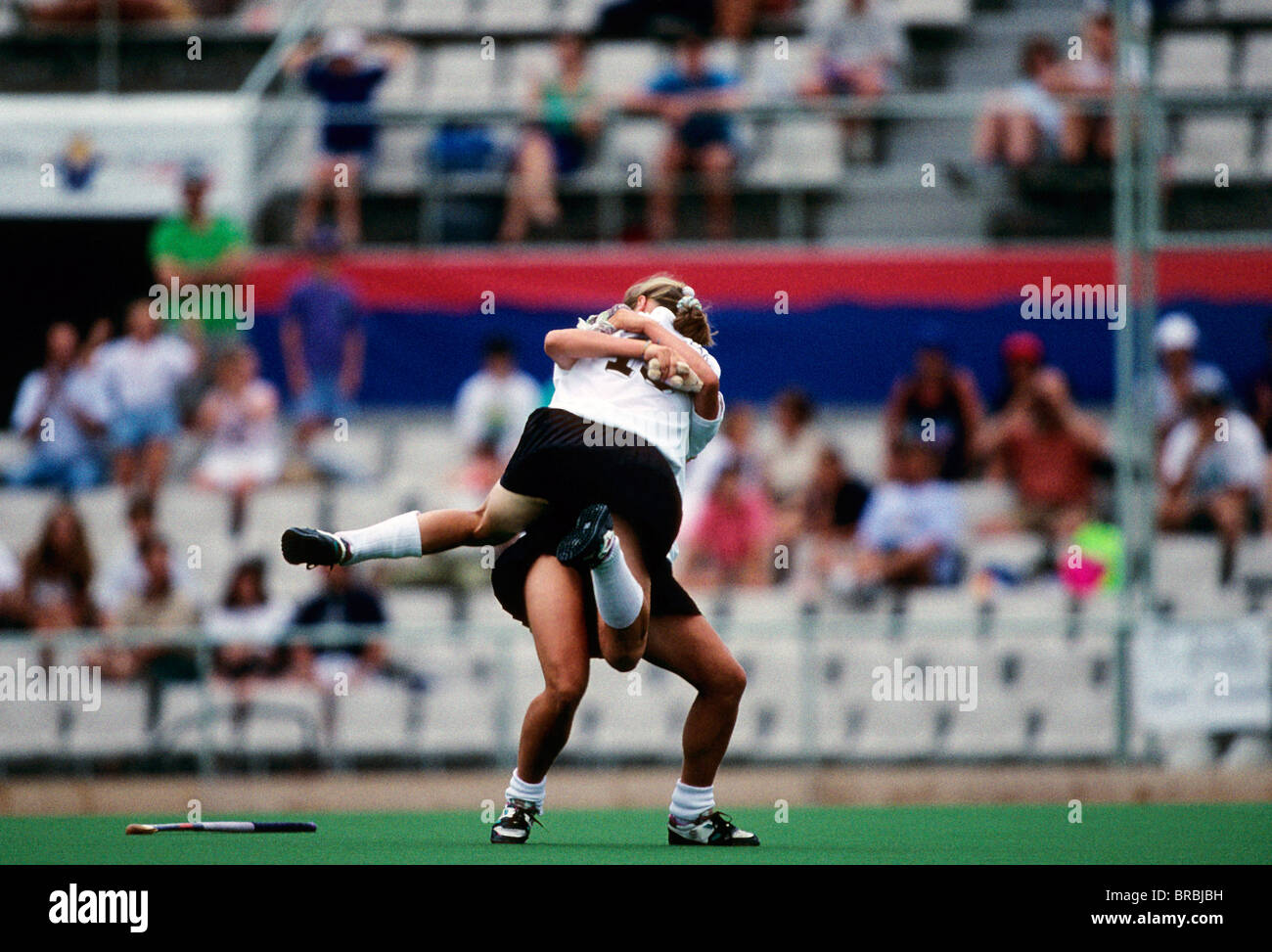 Two female hockey players hug each other as they win a game Stock Photo