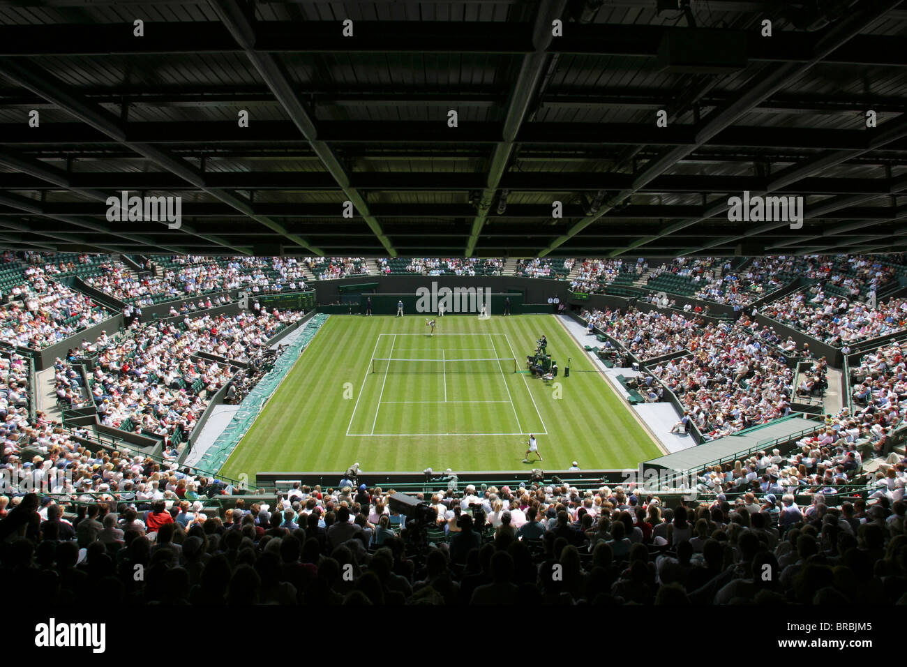Large crowd watching a tennis match on grass court Stock Photo