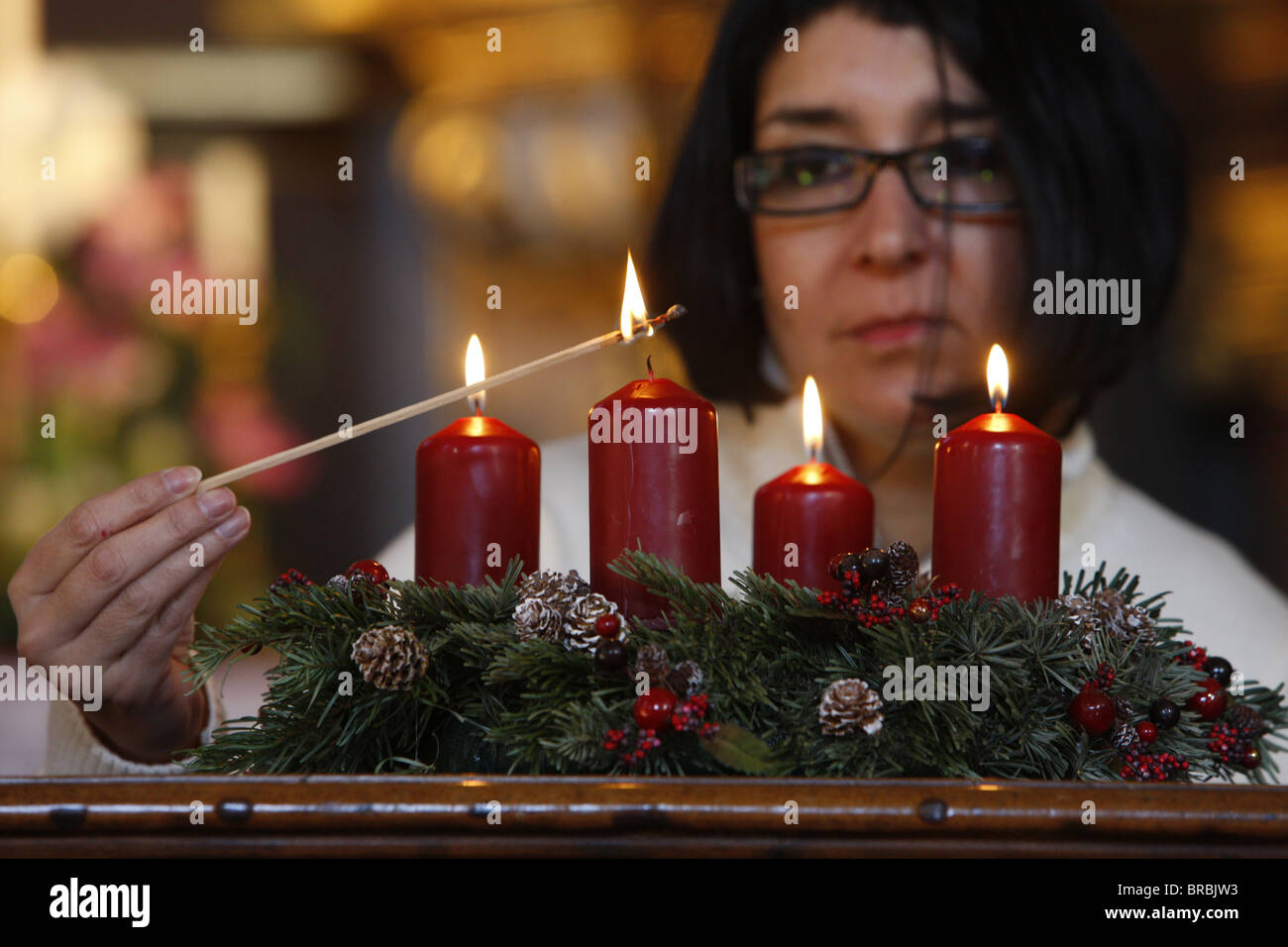 Woman lighting Advent candles, Saint-Nicolas de Veroce, Haute Savoie, France Stock Photo