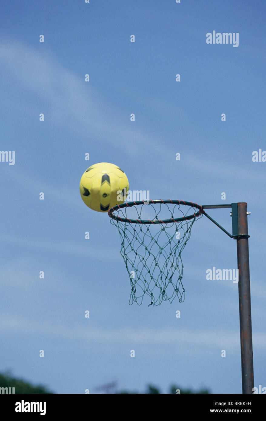 A netball going into the hoop net Stock Photo