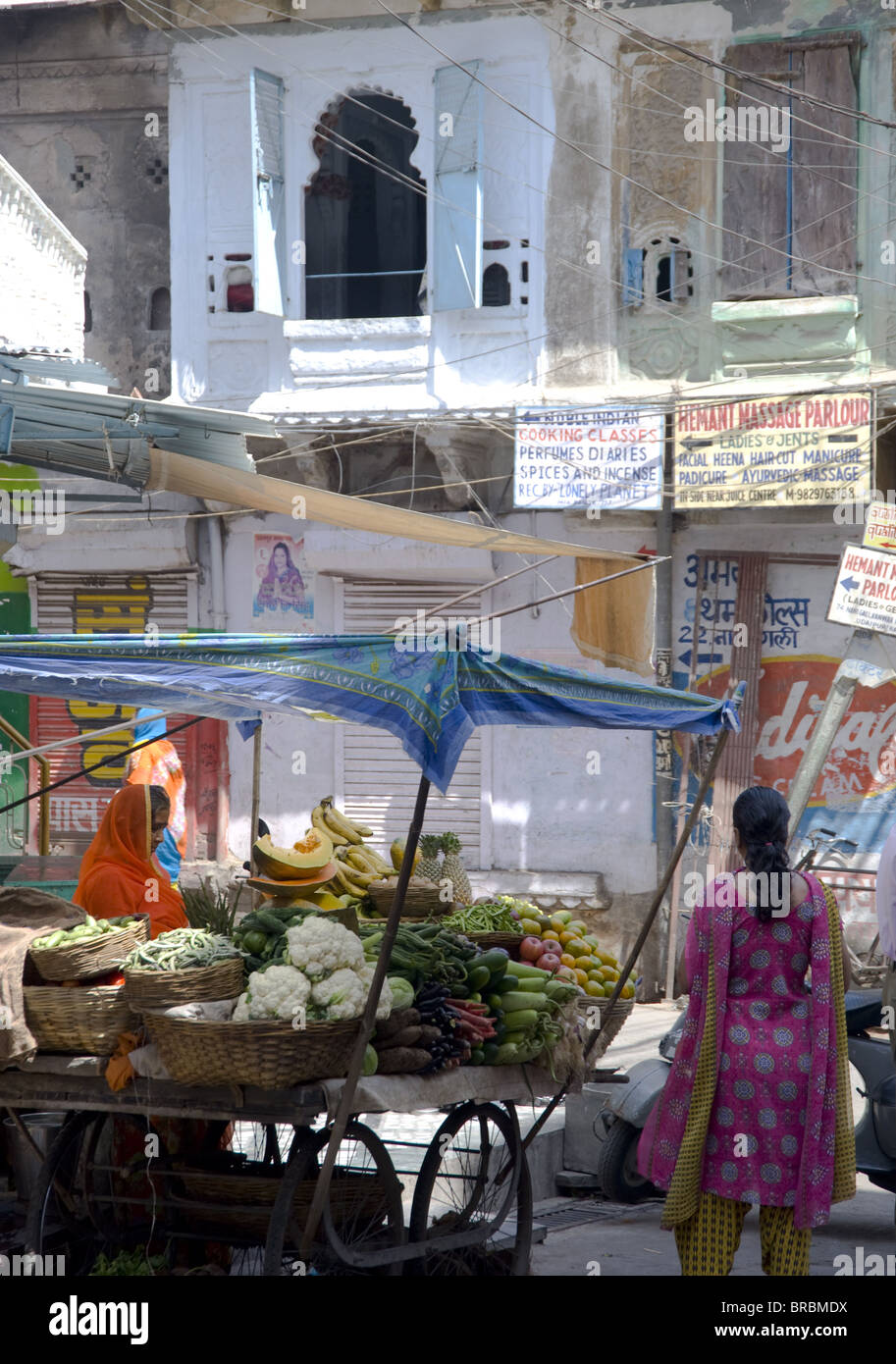 A woman selling fruit and vegetables at a stand in the old part of Udaipur, Rajasthan, India Stock Photo