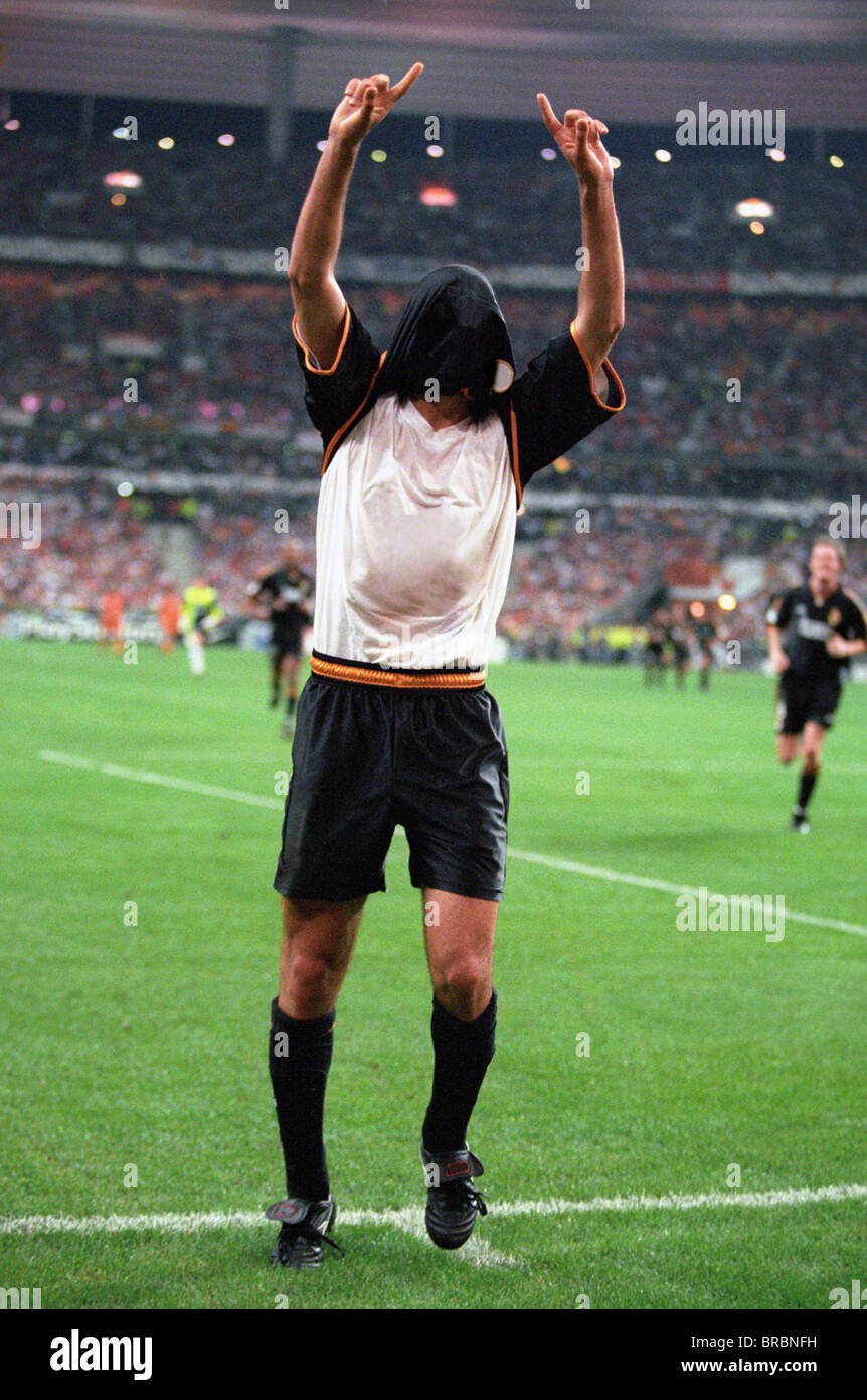 Footballer celebrates scoring goal in front of fans Stock Photo