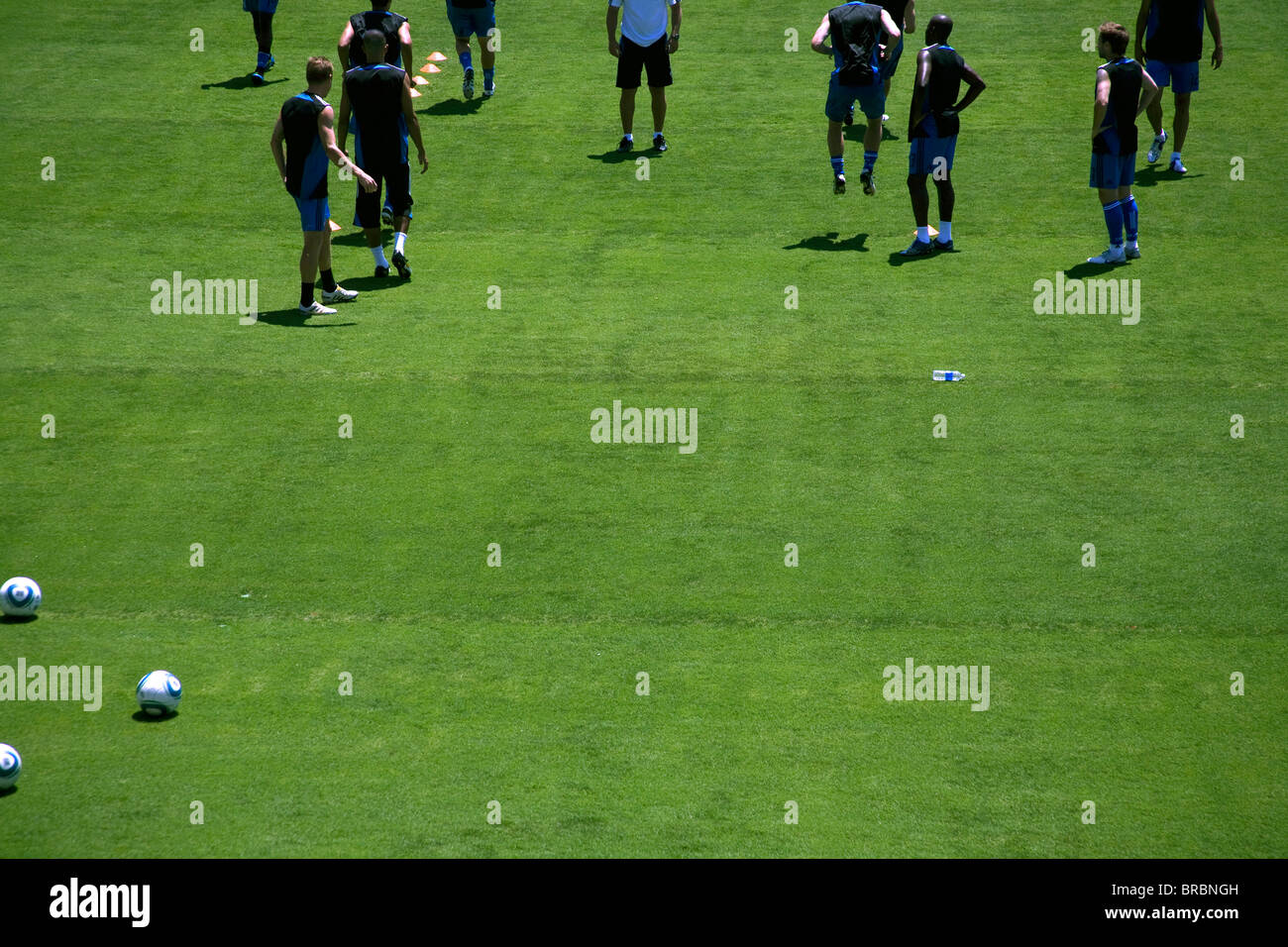 Footballers warm up pre-game on pitch Stock Photo