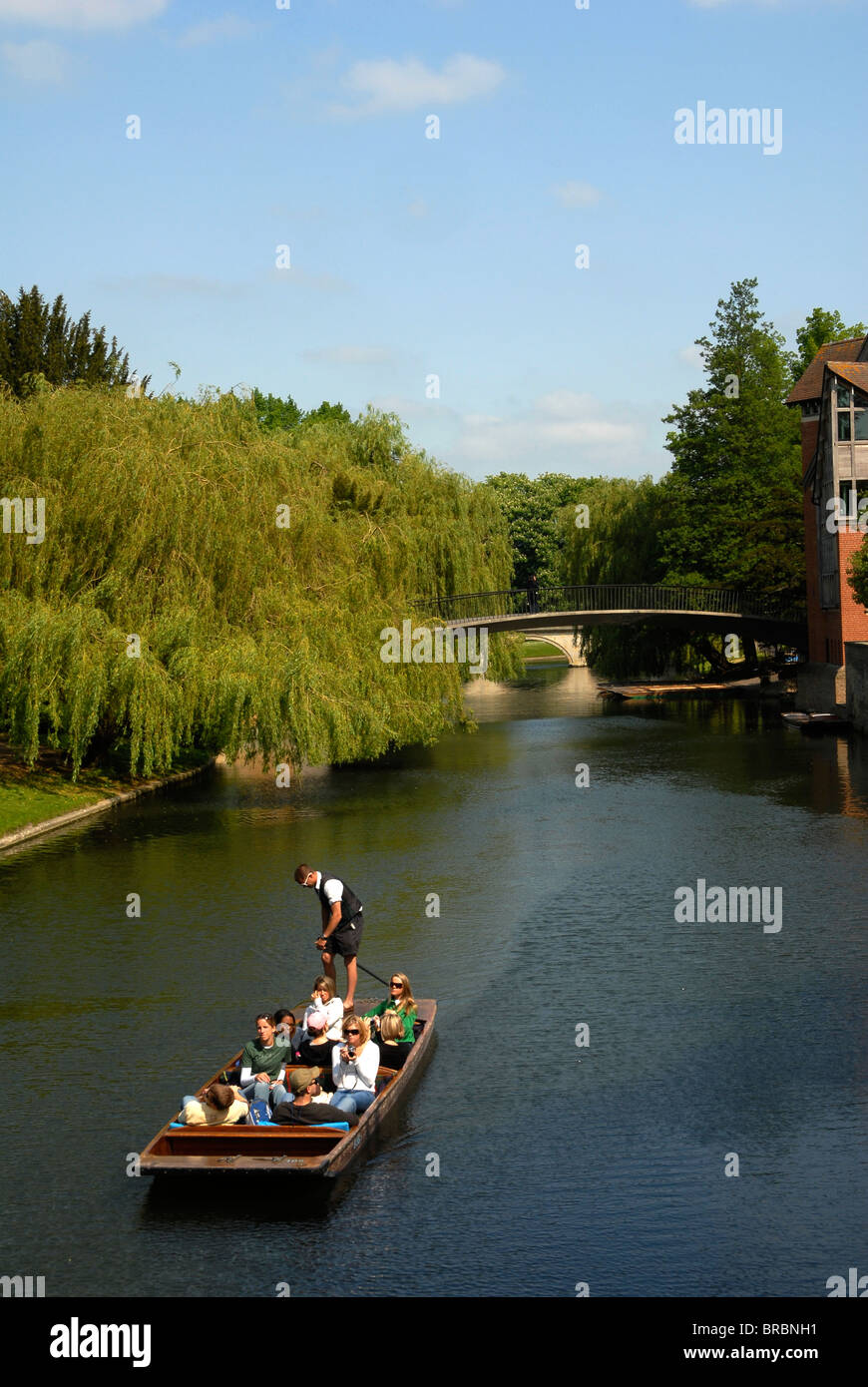 A party of tourists enjoying a chauffeured punt ride on the River Cam through central Cambridge Stock Photo
