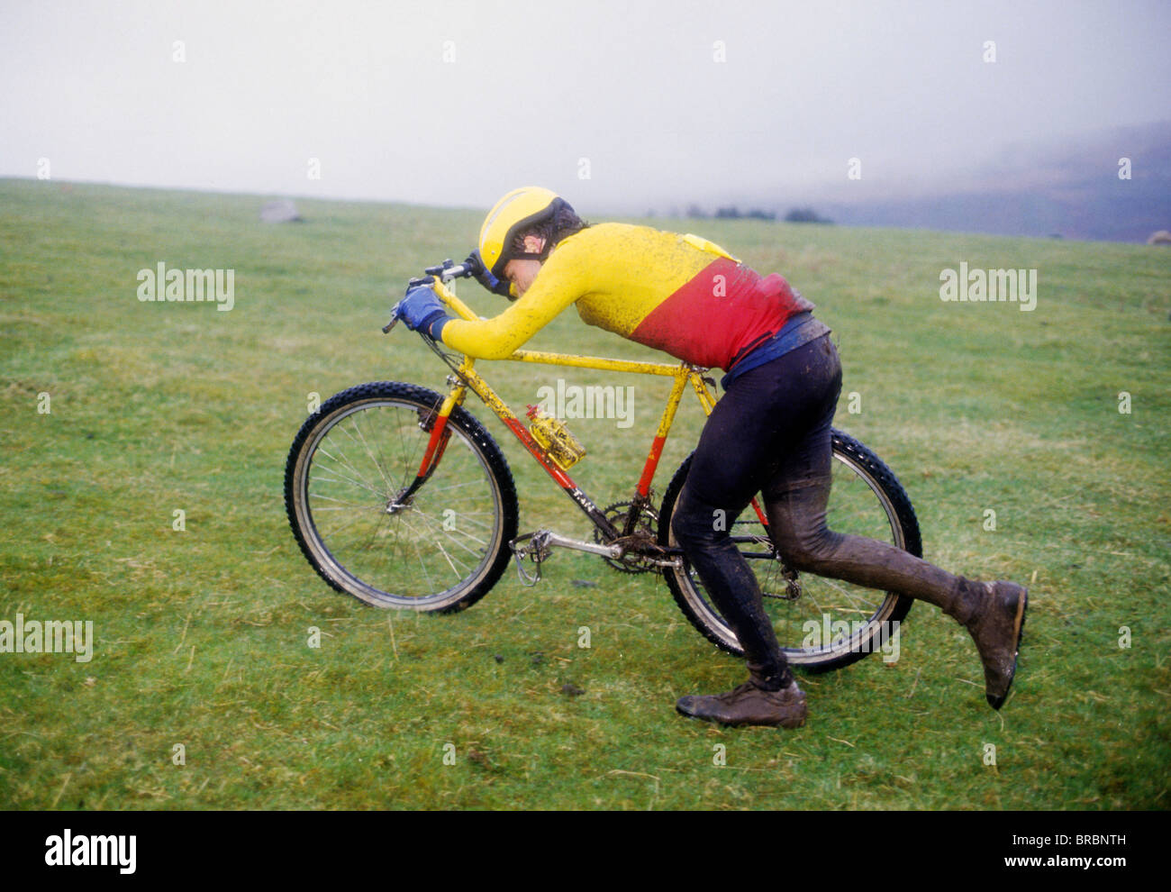 Mountain bike racer pushes his bike up hill course Stock Photo