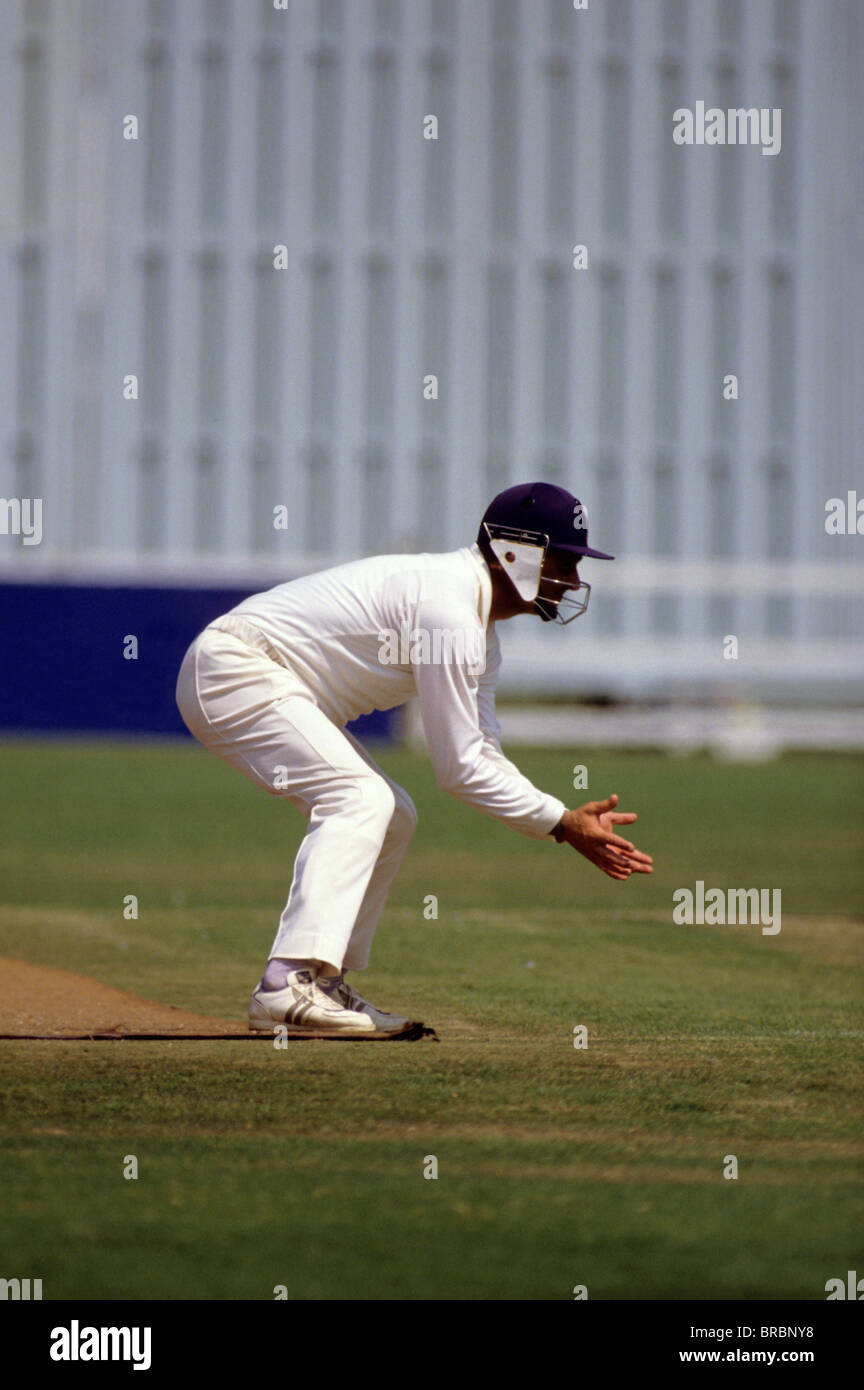 Cricketer with protective helmet waits for ball Stock Photo