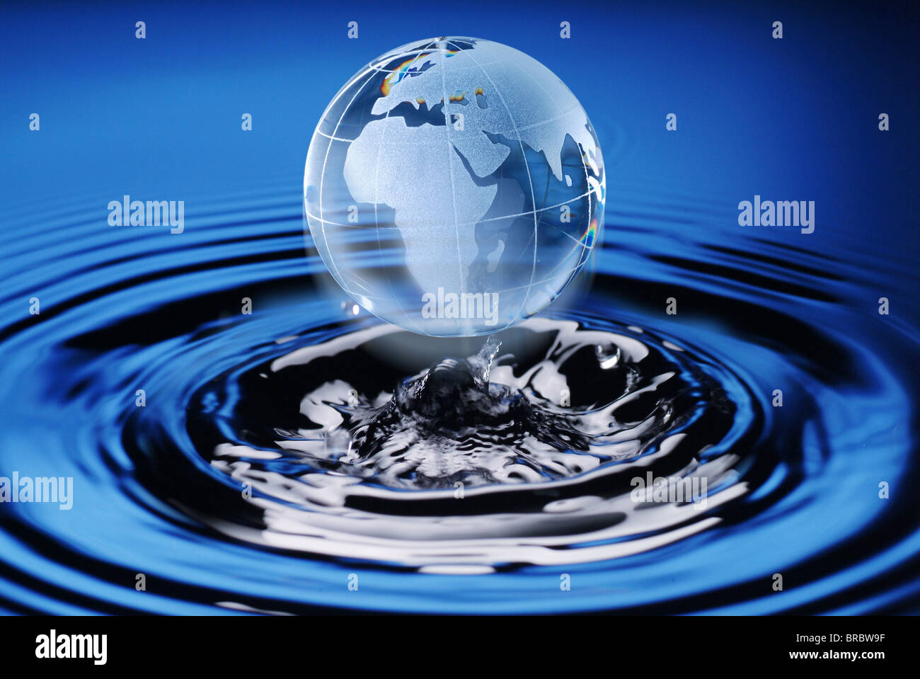 Glass globe emerging out of water Stock Photo