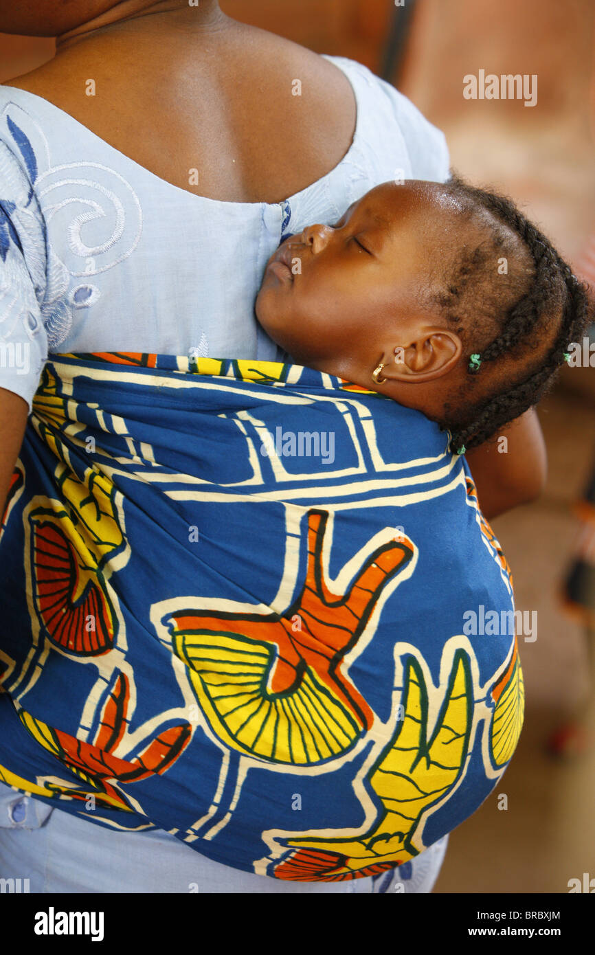 African mother carrying her baby on her back, Lome, Togo, West Africa Stock Photo