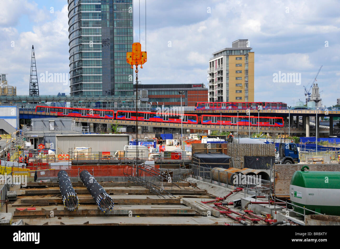 Construction site building substructure & superstructure new Canary Wharf Crossrail railway station with DLR train beyond East London England UK Stock Photo