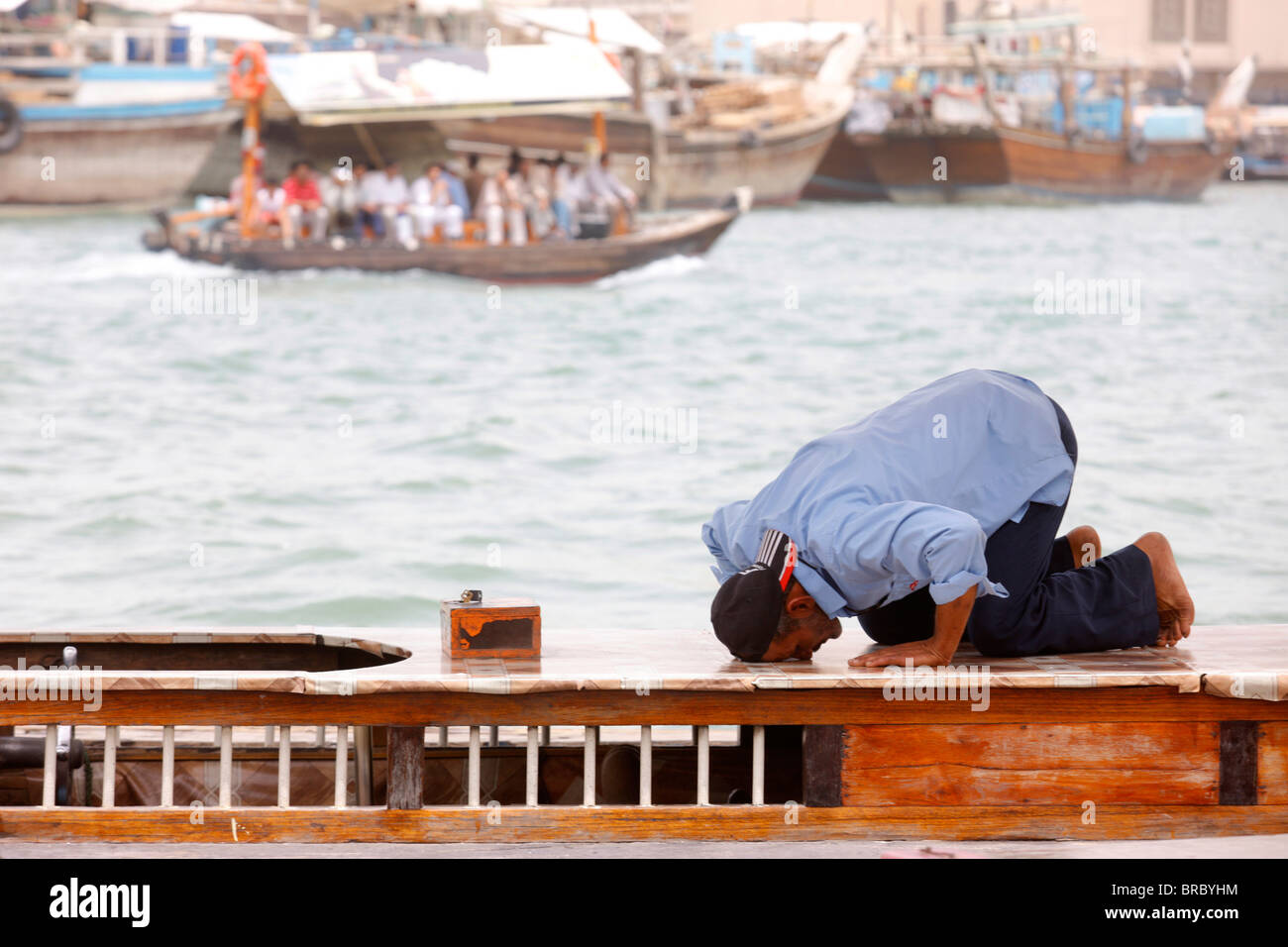 Praying muslim in Dubai harbour, Dubai, UAE Stock Photo