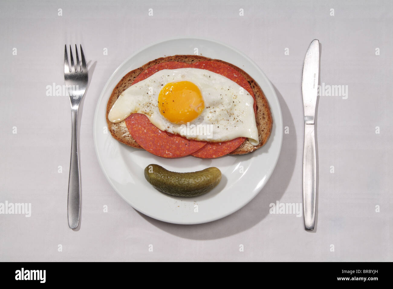 A sandwich with salami and fried eggs Stock Photo