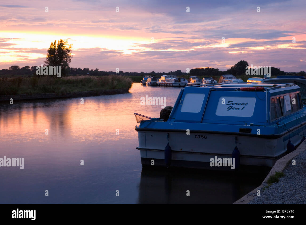 Pleasure boats moored on the River Ant, sunset, Norfolk Broads, Ludham, Norfolk, England, UK Stock Photo
