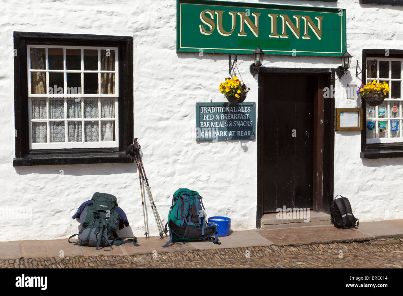 Hikers' rucksacks and trekking poles outside the Sun Inn in the village of Dent, Dentdale, Cumbria Stock Photo