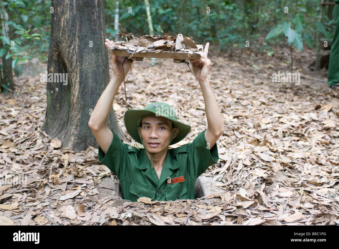 Soldier showing the entrance to the former Viet Cong tunnels of ChuChi, near Saigon, Vietnam, Indochina Stock Photo