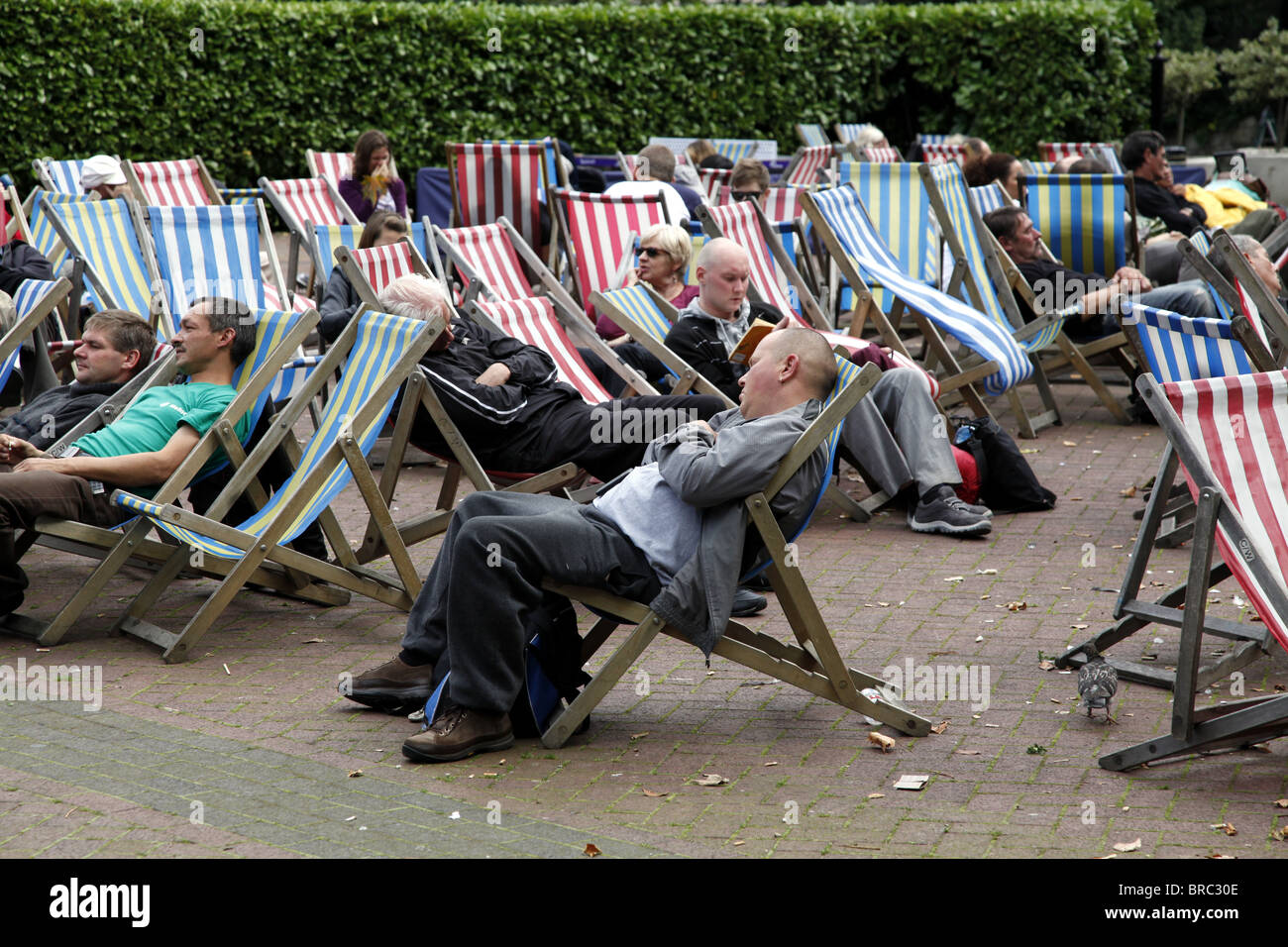 People relaxing in deckchairs. Embankment. London Stock Photo
