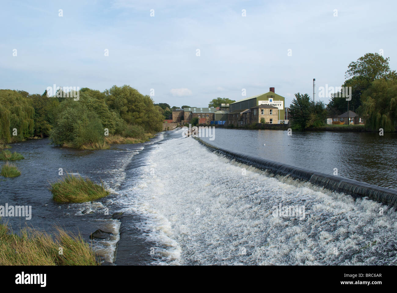 The weir and a paper factory on the river Wharfe at Otley Leeds West Yorkshire UK Stock Photo