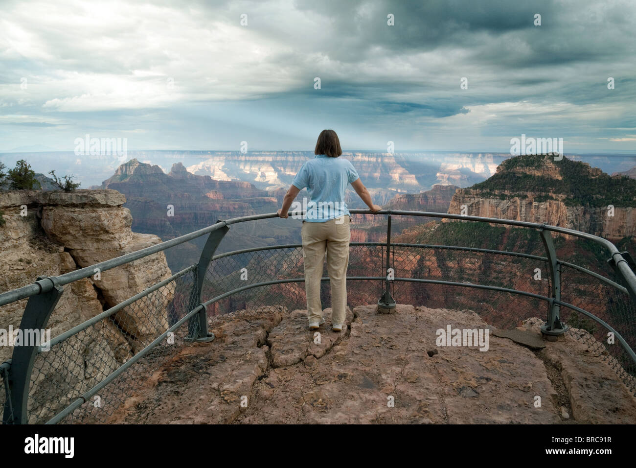 A woman looking out at the Grand Canyon from North Rim, Arizona, USA ...
