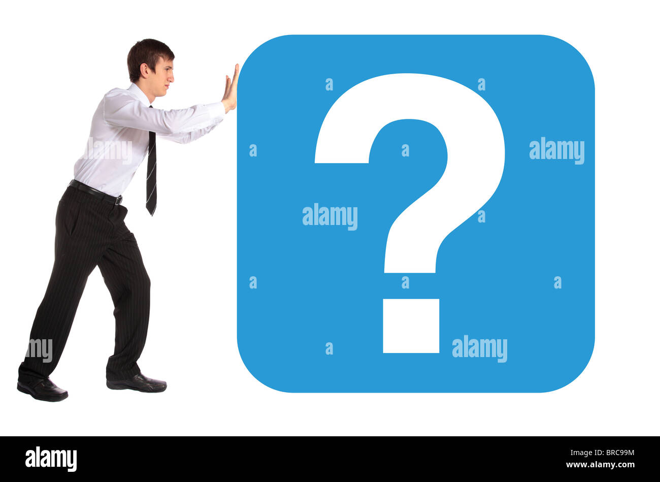A young business man pushing a huge question mark. All isolated on white background. Stock Photo