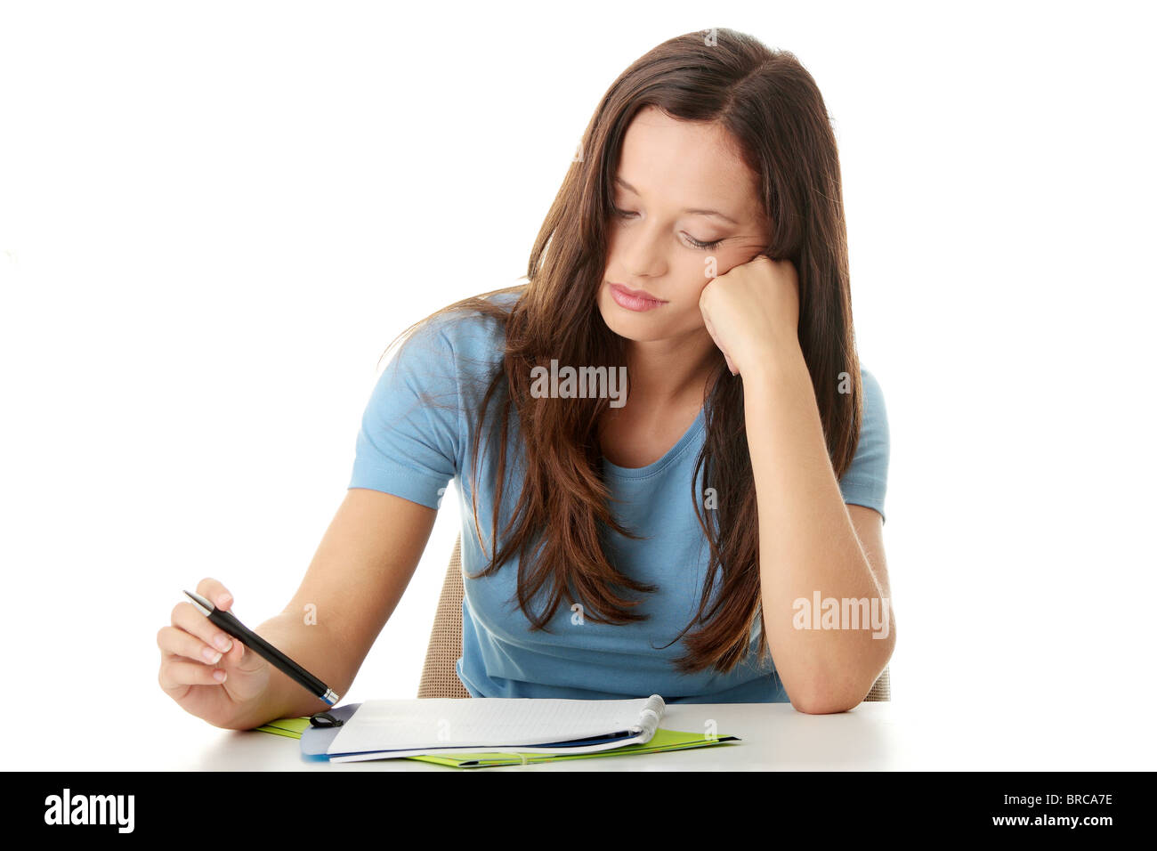 Teenage Girl Studying At The Desk Being Tired Isolated On White
