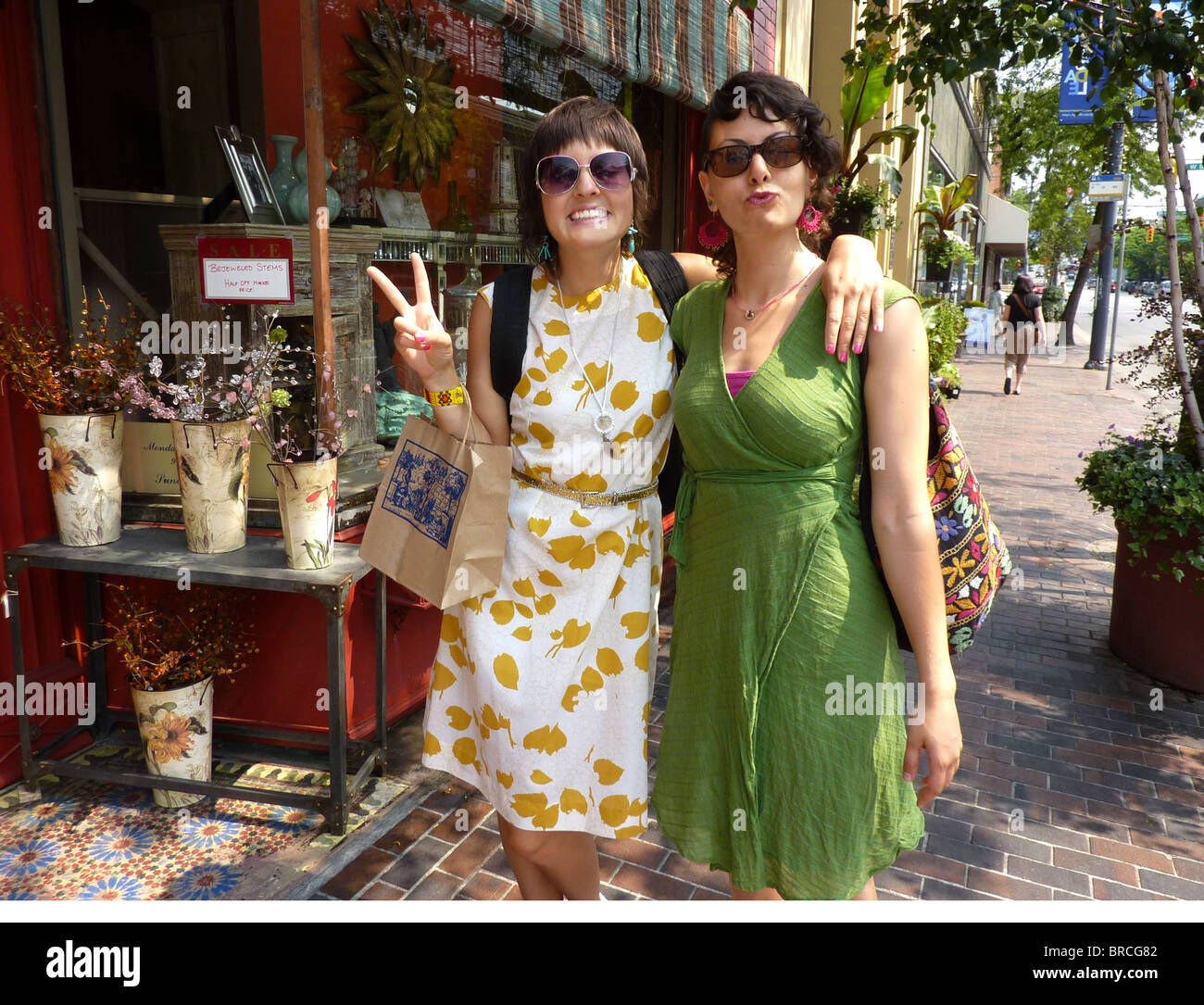 Two young woman shopping on sidewalk Stock Photo