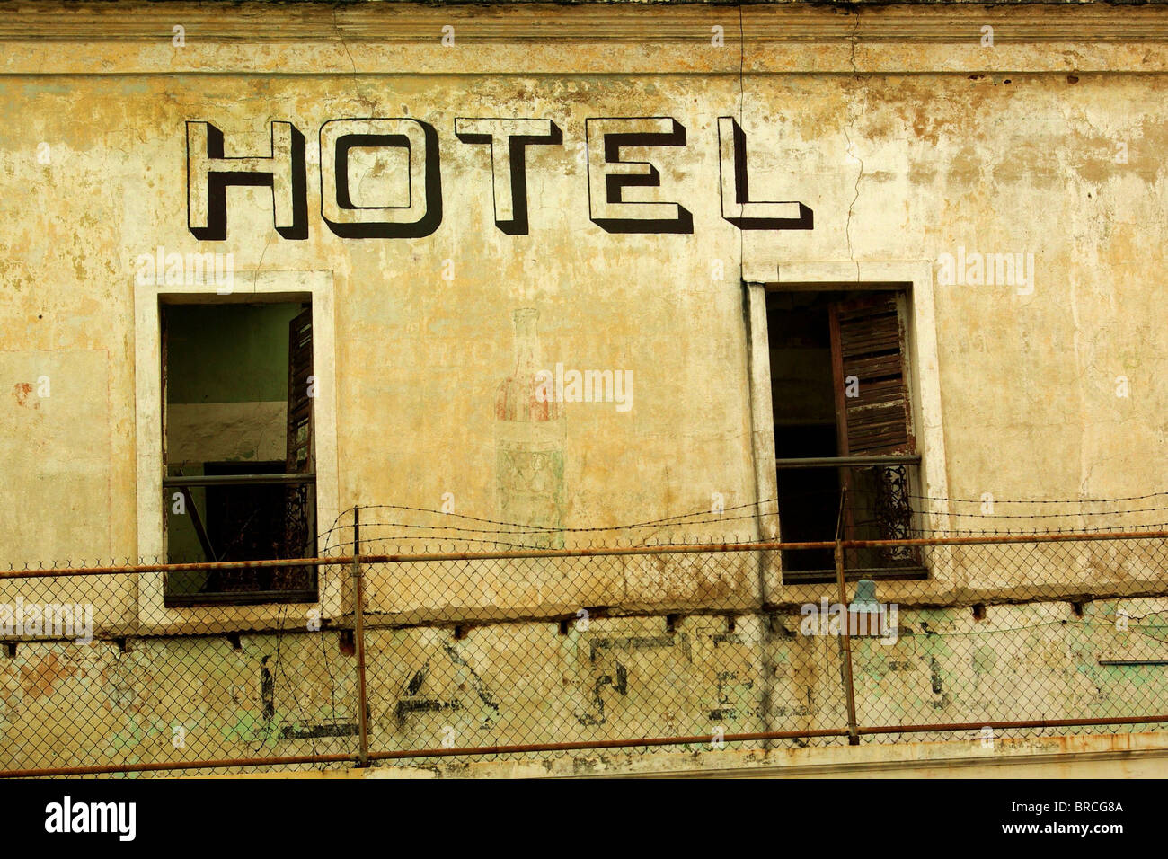 Abandoned hotel with no windows surrounded by wire fence Stock Photo