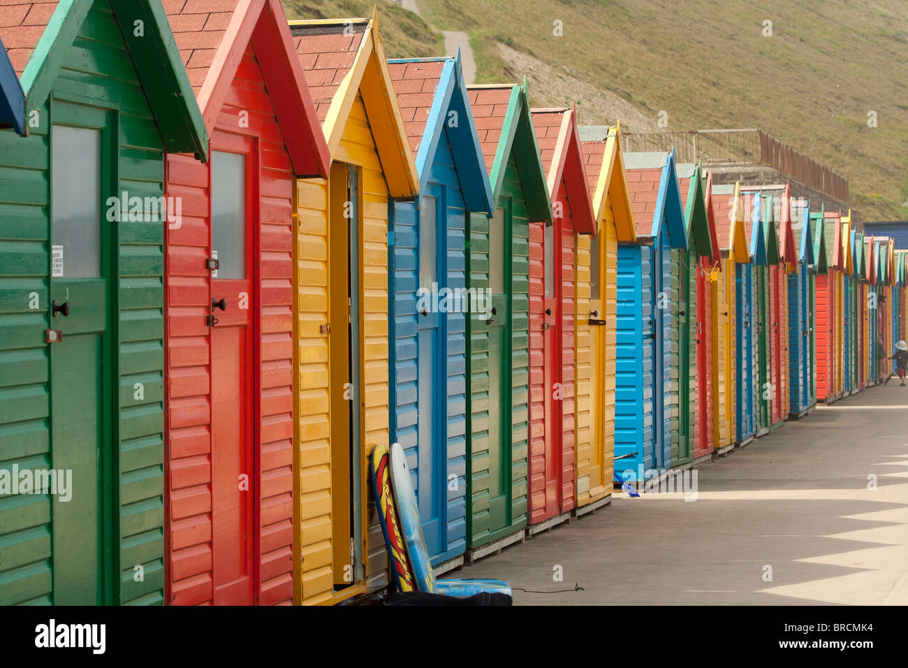 Typically British brightly colored row of beach huts  at English seaside resort. Stock Photo