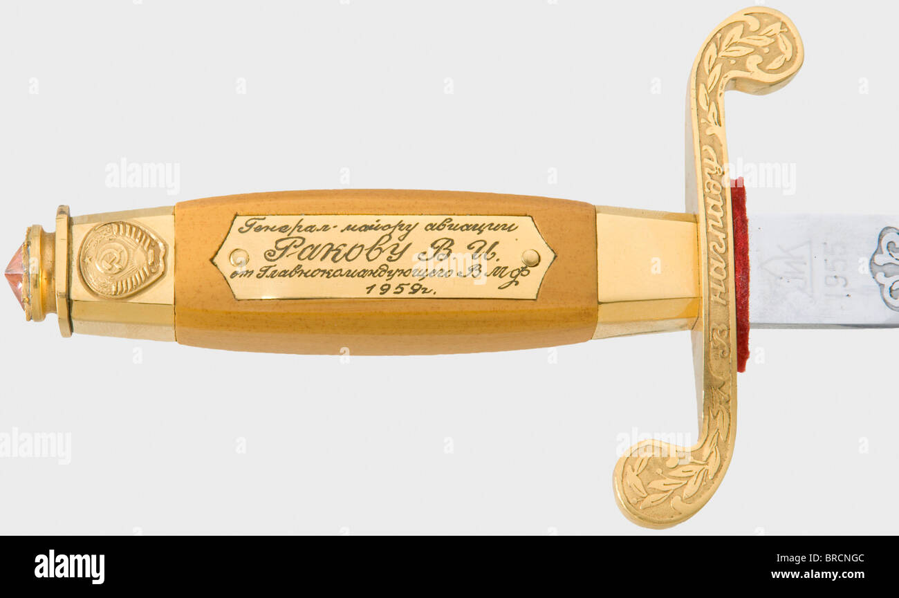 Air Commodore Vassily Ivanovich Rakov (1909 - 1996), a navy honour dagger, 1959 Nickel-plated blade with decorative laurel etching, manufacturer 'ZIK 1955', 'N.0598'. Gold-plated brass hilt with Soviet arms and red rhinestone on the pommel. Yellow plastic grip with dedication plaque and Cyrillic engraving 'To Airforce Commodore Rakov V.I. from the Navy's Commander-in-Chief 1959'. Black leather-covered scabbard, gilt brass fittings with oak leaf and navy motifs. Length 31.7 cm. Comes with original wooden presentation case inlaid in red velvet. V.I. Rakov, twice , Stock Photo