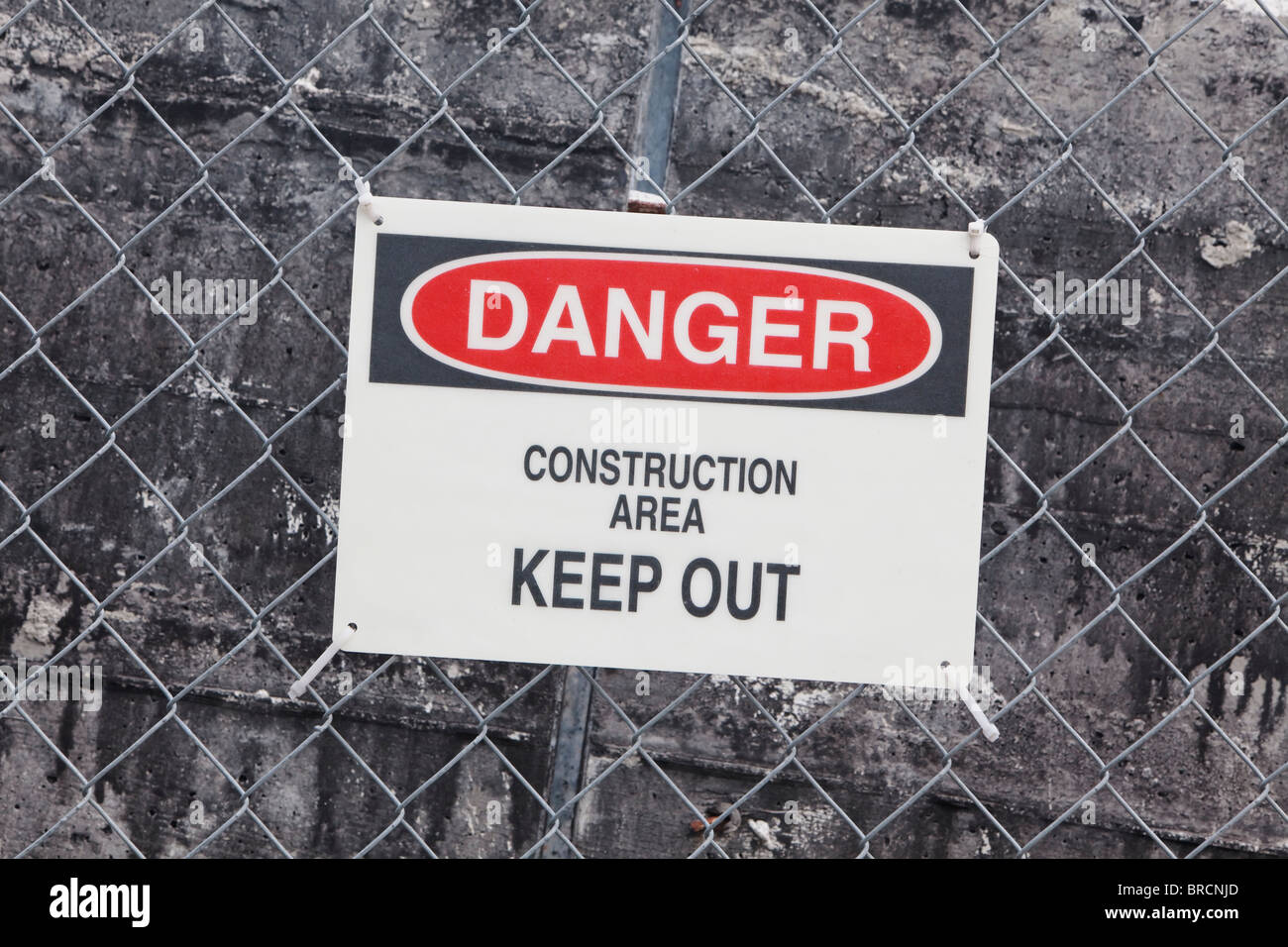 danger construction site sign mounted on fence surrounding construction