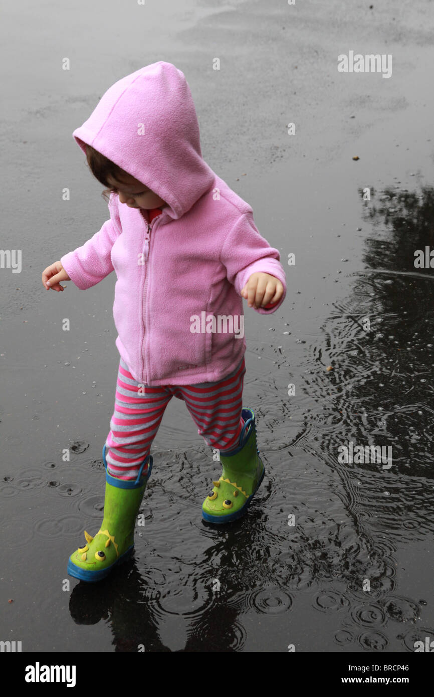 A small girl walking in the rain. Stock Photo