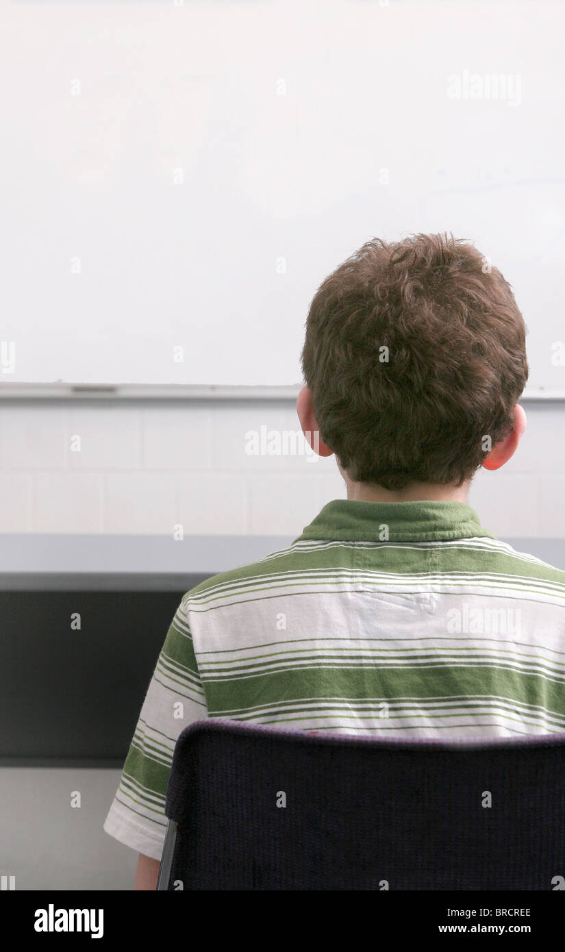 one young male student in a classroom sitting at his desk Stock Photo ...