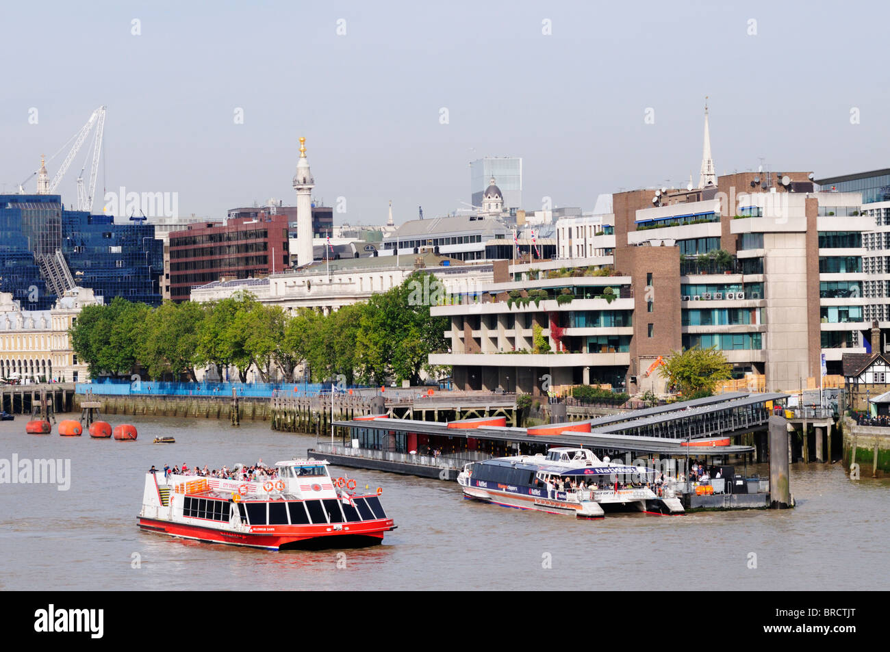 Thames Clippers Riverbus and City Cruises tour boat at Tower Pier, London, England, UK Stock Photo