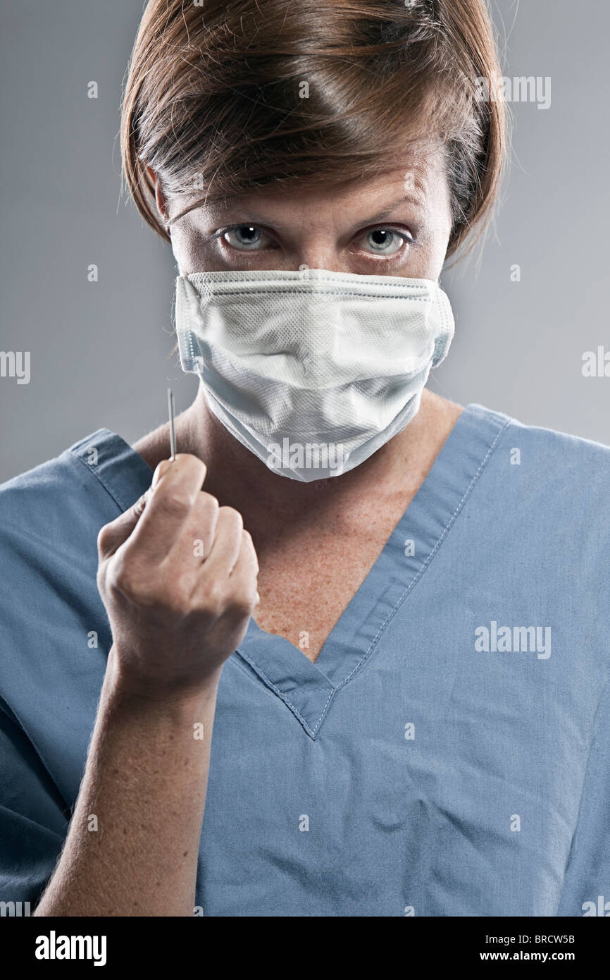 Shot of a Sinister Looking Female Doctor against Grey Background Stock Photo