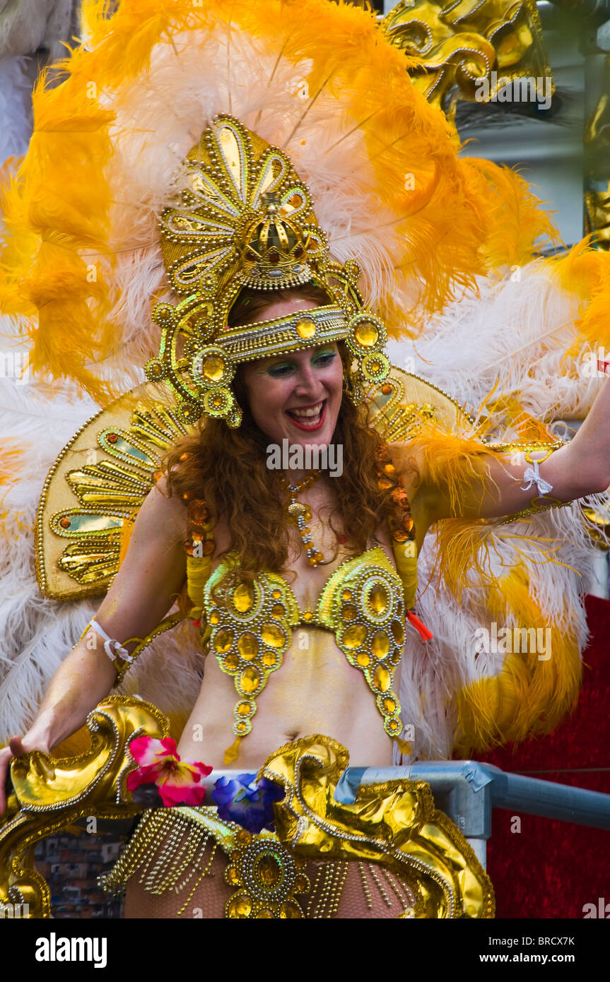 A colourful and costumed female street performer aboard a float at the