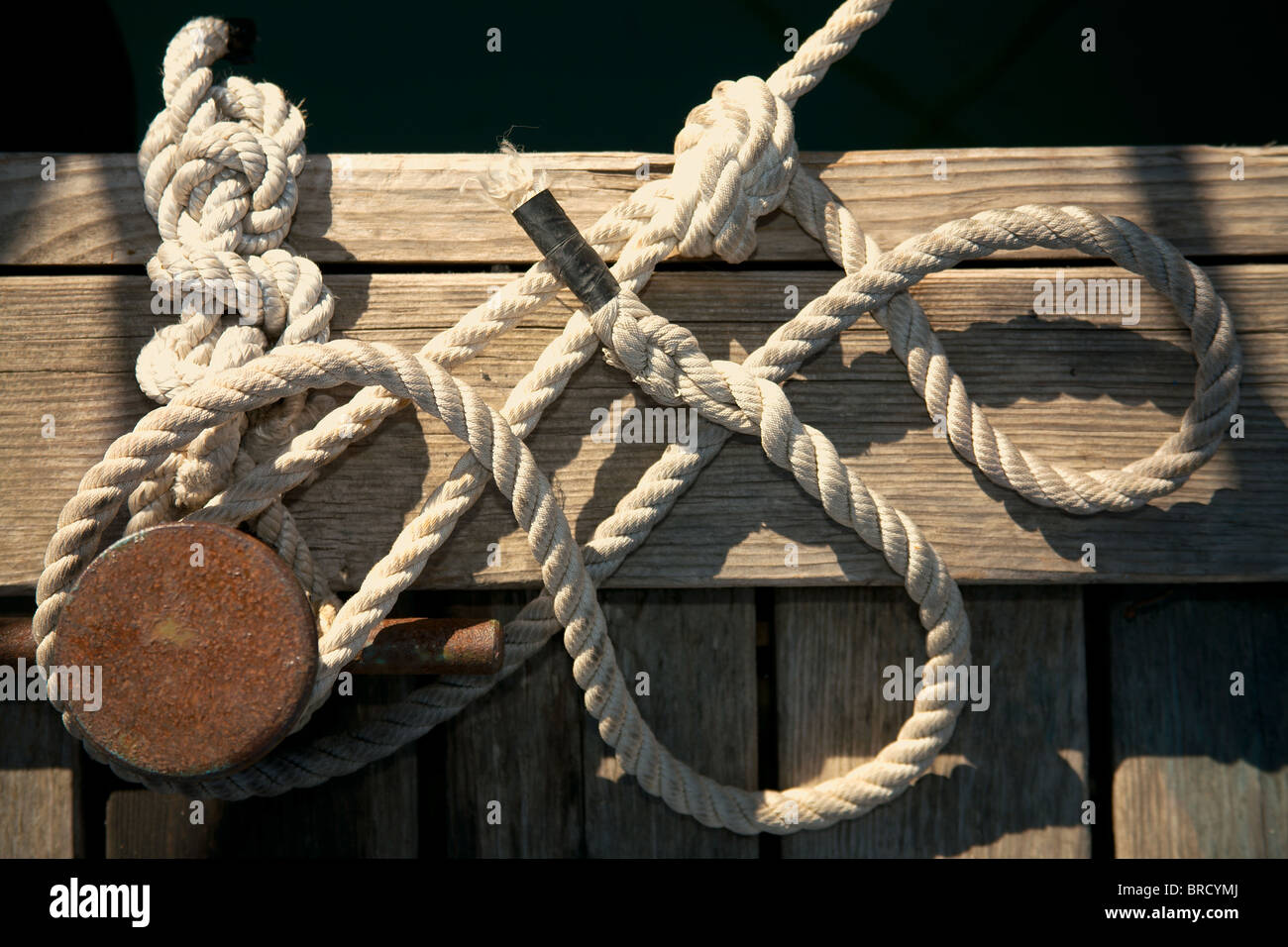 Rope for mooring a vessel is adhered to a pier Stock Photo