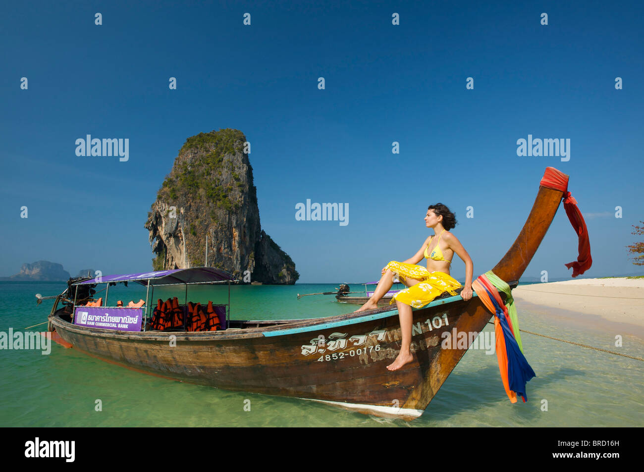 Woman relaxing on a long-tail boat at Laem Phra Nang Beach, Krabi, Thailand Stock Photo