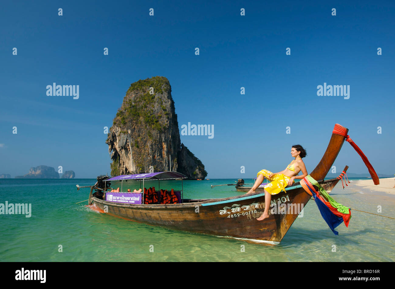 Woman relaxing on a long-tail boat at Laem Phra Nang Beach, Krabi, Thailand Stock Photo