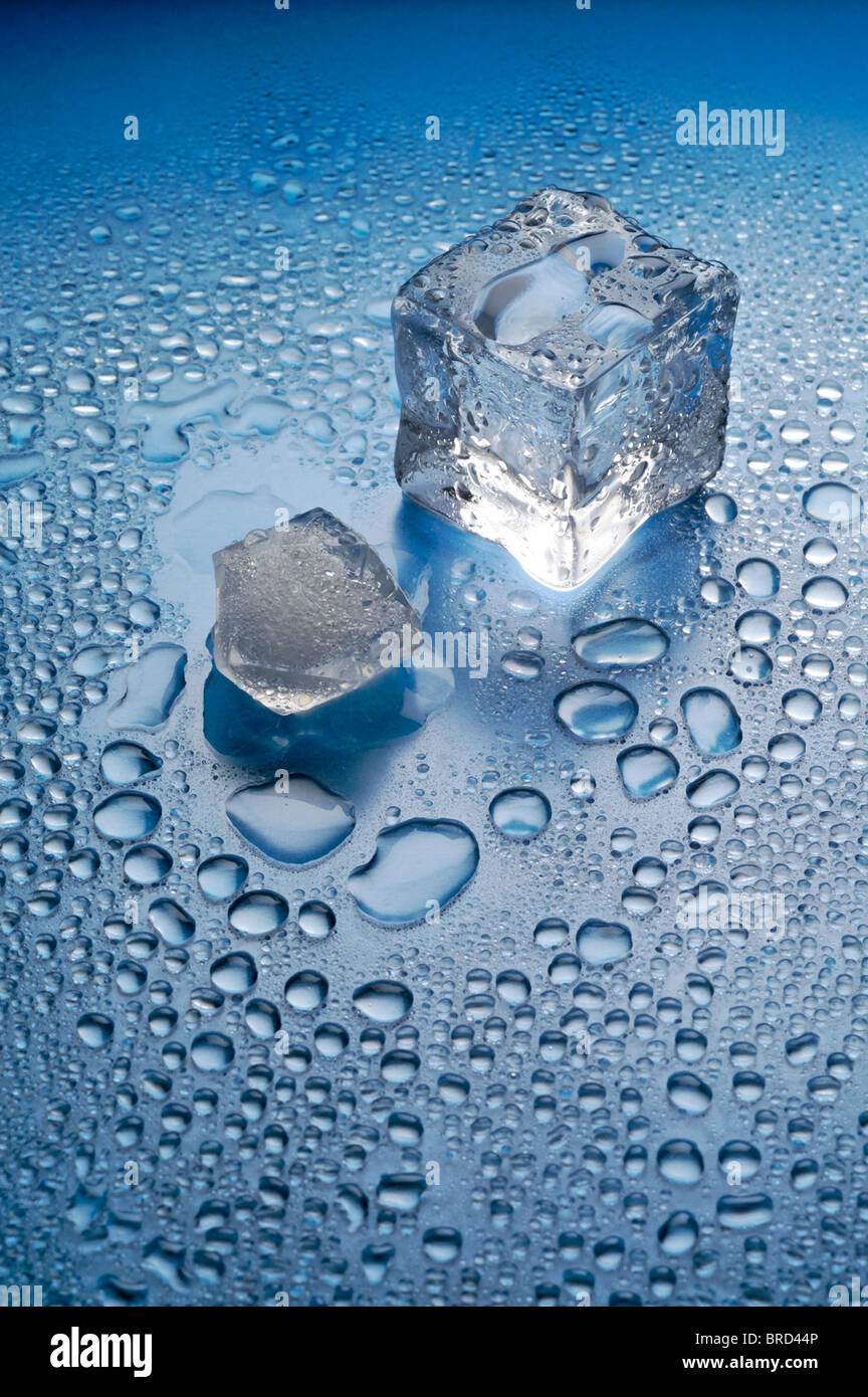 Melting ice on blue background vertical Stock Photo