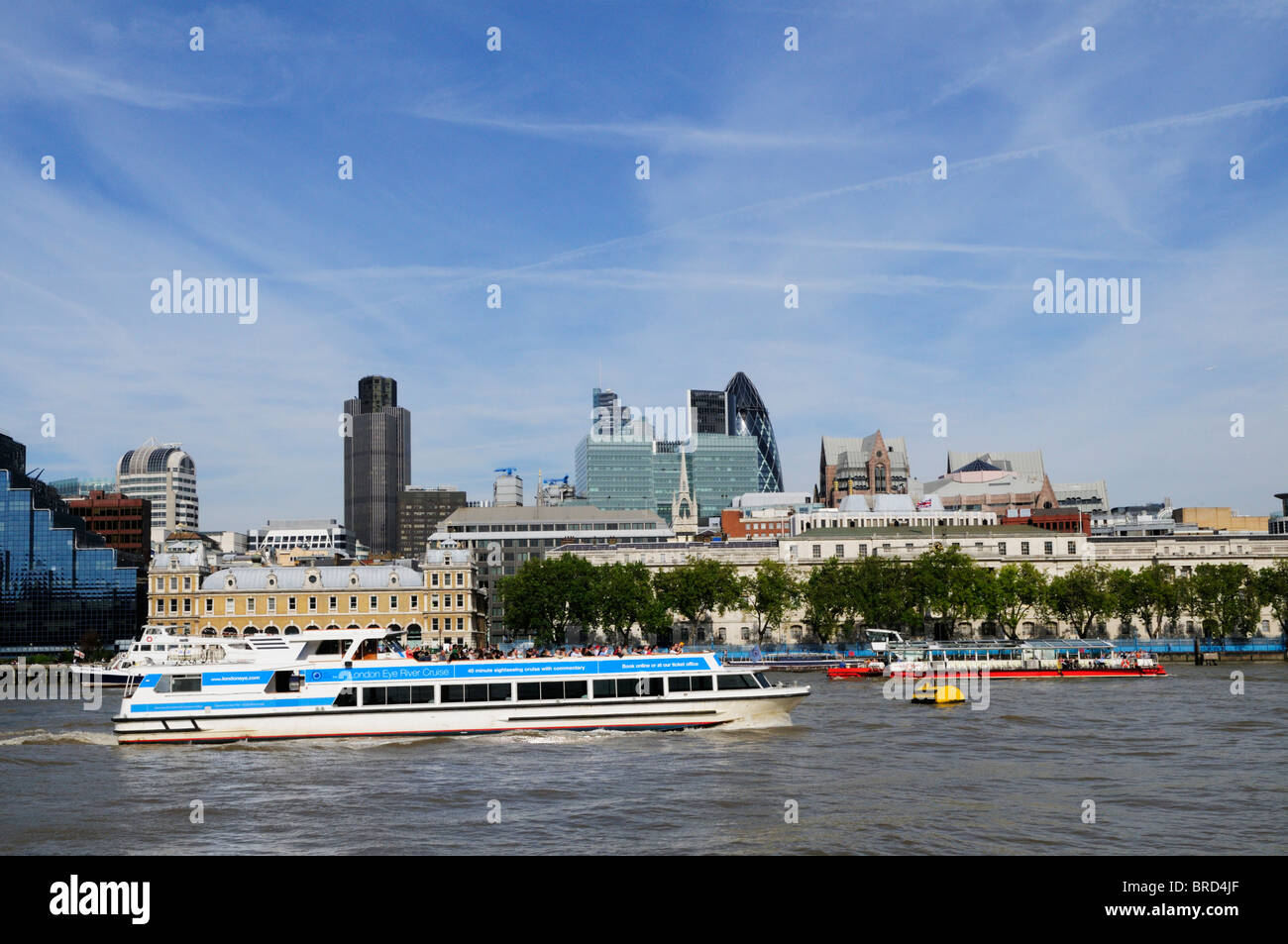 Tourist Sightseeing cruise boats on the River Thames, with City of London buildings in the background, London, England, UK Stock Photo