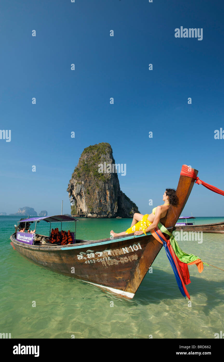 Woman relaxing on a long-tail boat at Laem Phra Nang Beach, Krabi, Thailand Stock Photo