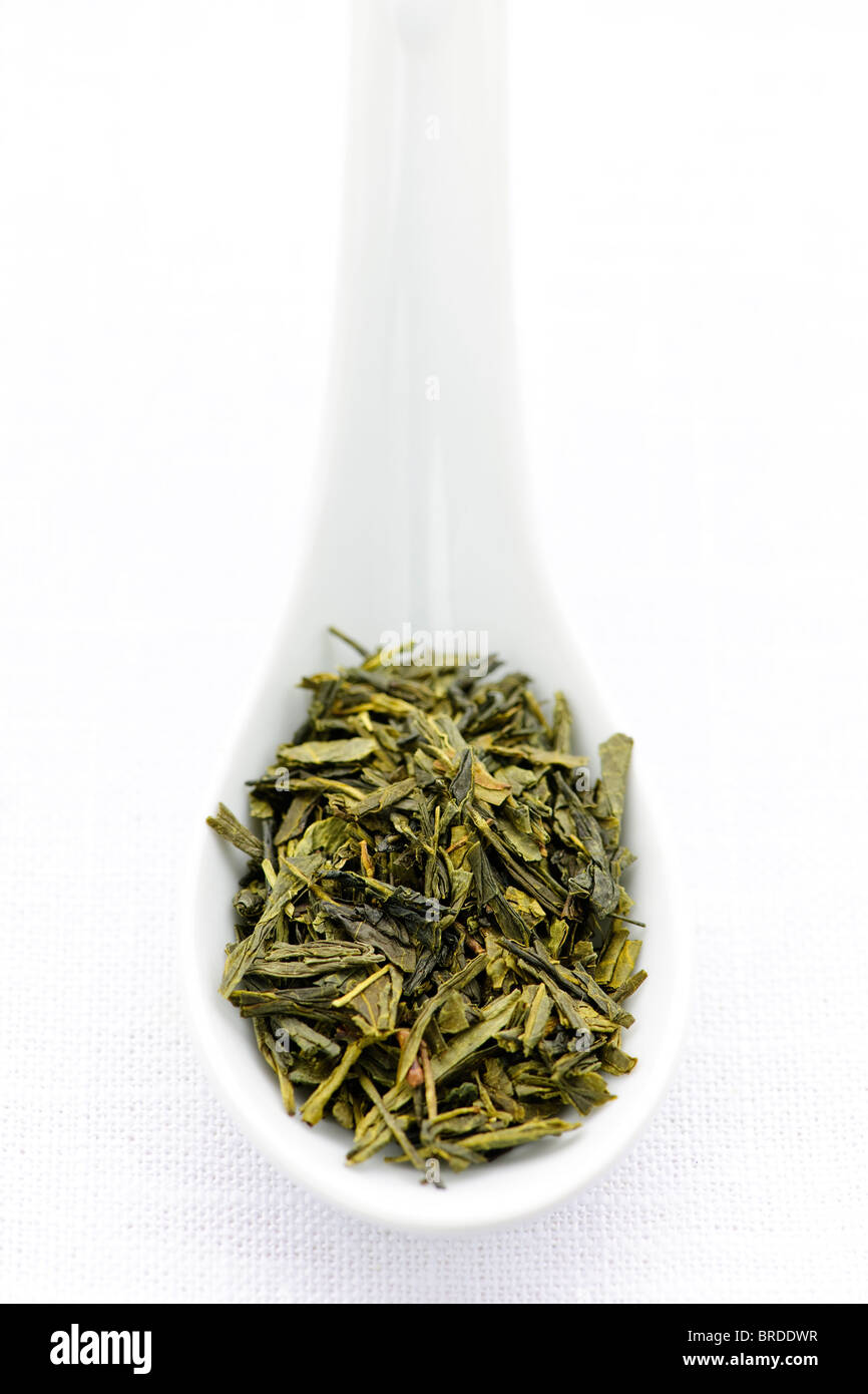 Green dry tea leaves on a spoon Stock Photo