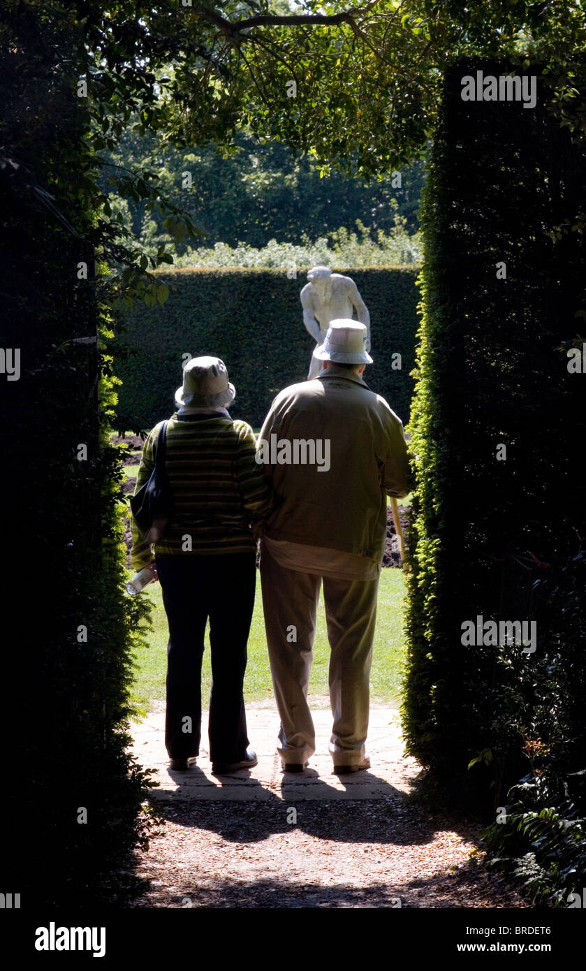Elderly couple viewing statue at Anglesey Abbey, Jacobean-style country house in Cambridgeshire UK Stock Photo