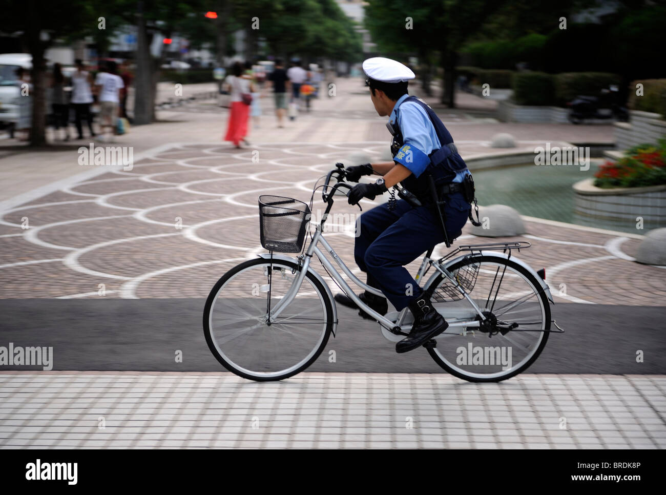 A Japanese police man patrols the street with a bicycle in Yokosuka, Japan. 20-Sep-2010 Stock Photo