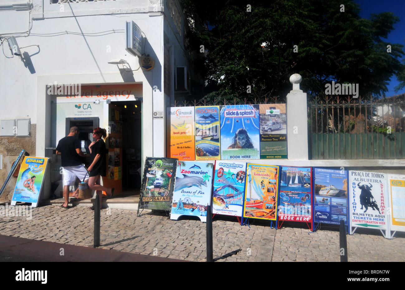 Tourists at a travel agency selling excursions in the Algarve, Portugal Stock Photo