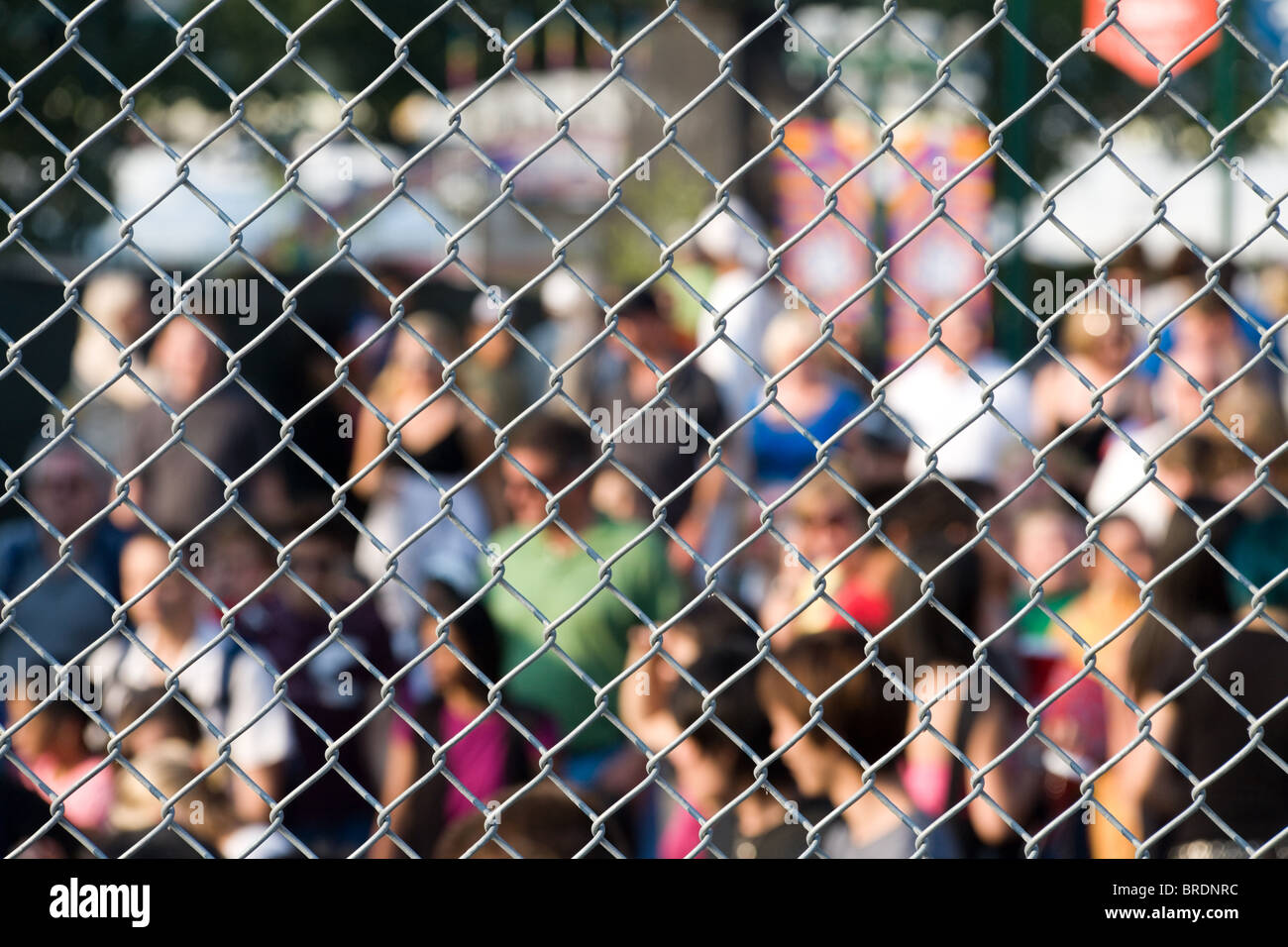 Metal netting and crowd, focus on metal netting Stock Photo