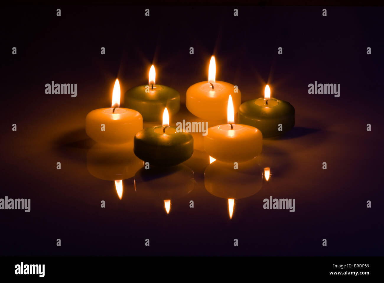 Six candles on a dark reflective ground Stock Photo Alamy