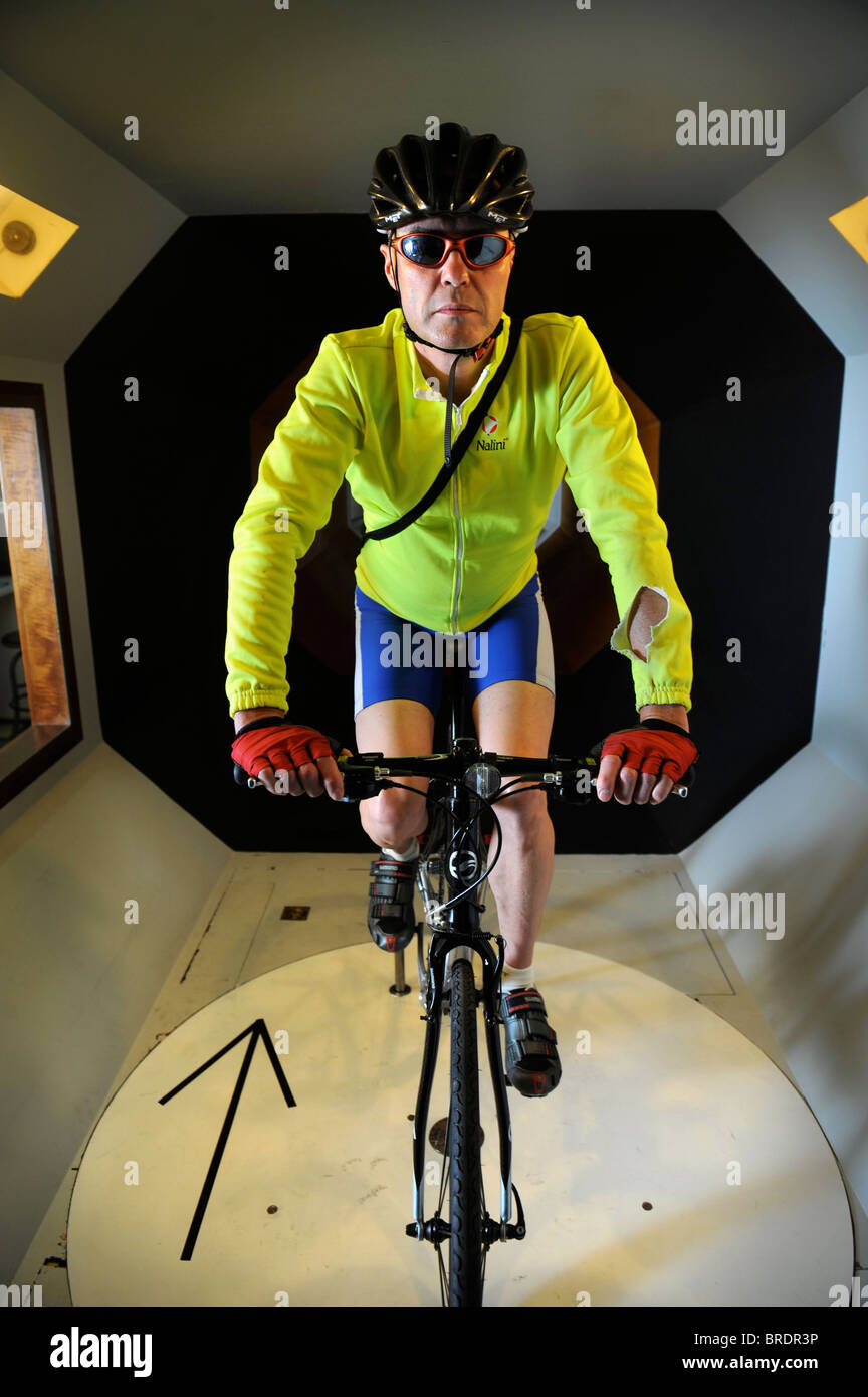 A test cyclist rides a road bike in a wind tunnel experiment for