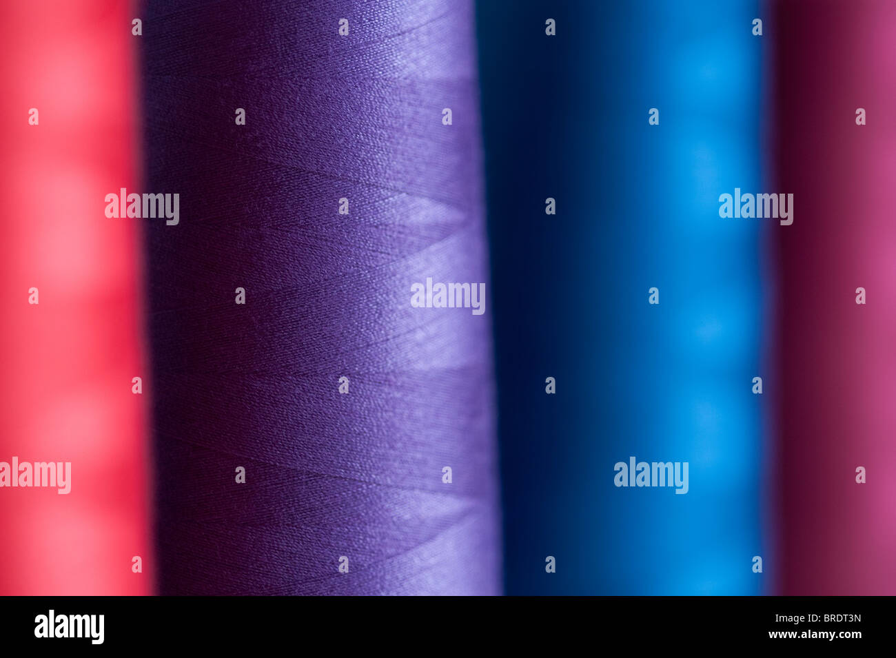 Multicolored spools of thread on a spindle on a serger sewing machine